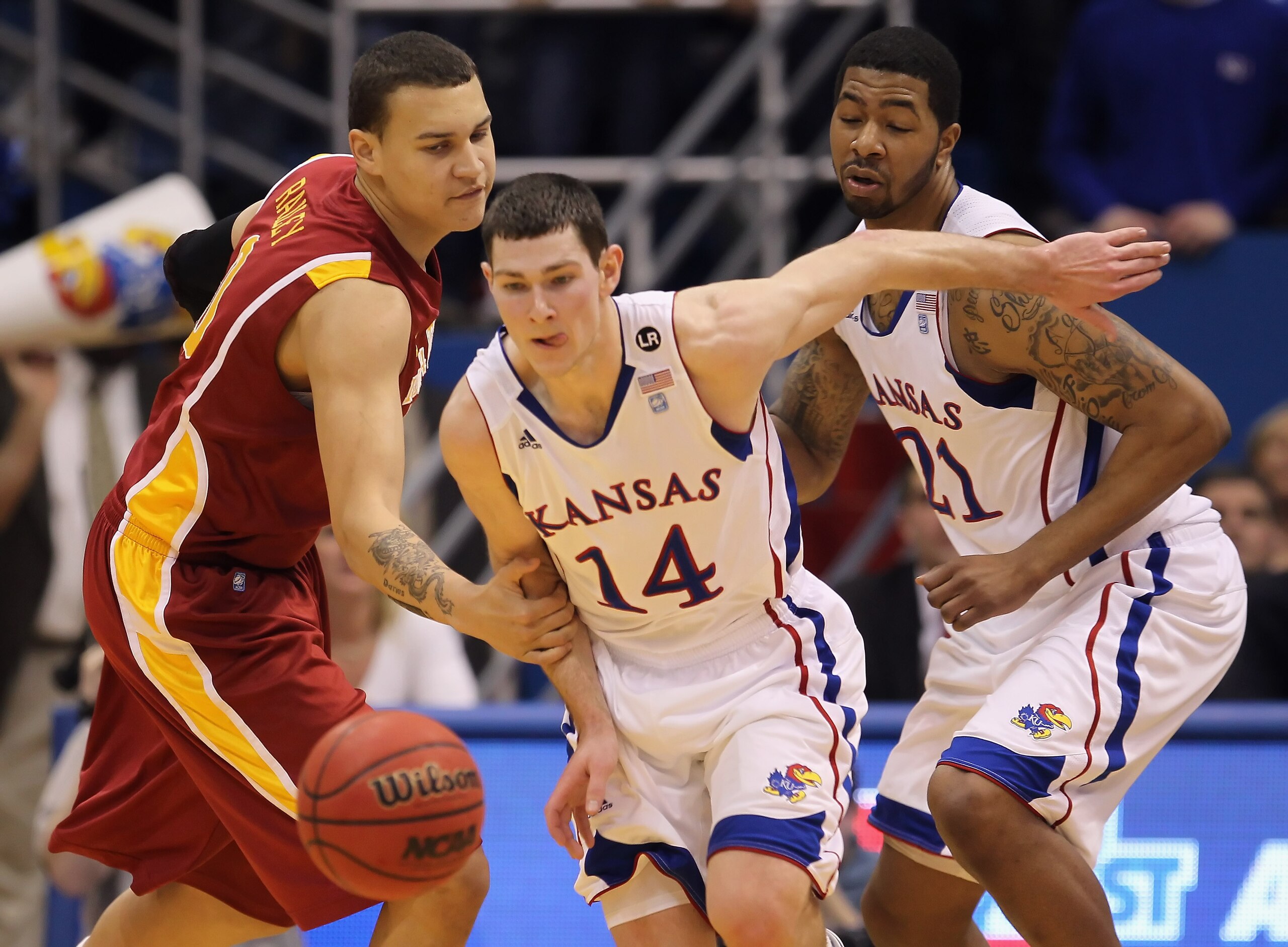 LAWRENCE, KS - FEBRUARY 12:  Jordan Railey #0 of the Iowa State Cyclones fouls Tyrel Reed #14 of the Kansas Jayhawks on a loose ball as Markieff Morris #21 looks on during the game on February 12, 2011 at Allen Fieldhouse in Lawrence, Kansas.  (Photo by J