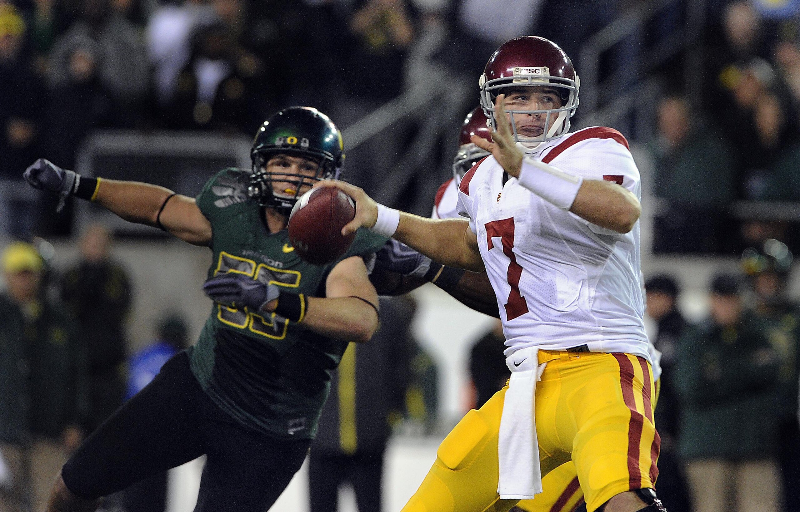 EUGENE, OR - OCTOBER 31: Quarterback Matt Barkley #7 of the USC Trojans sets to throw a pass as linebacker Casey Matthews #55 of the Oregon Ducks applies pressure in the third quarter of the game at Autzen Stadium on October 31, 2009 in Eugene, Oregon. Or