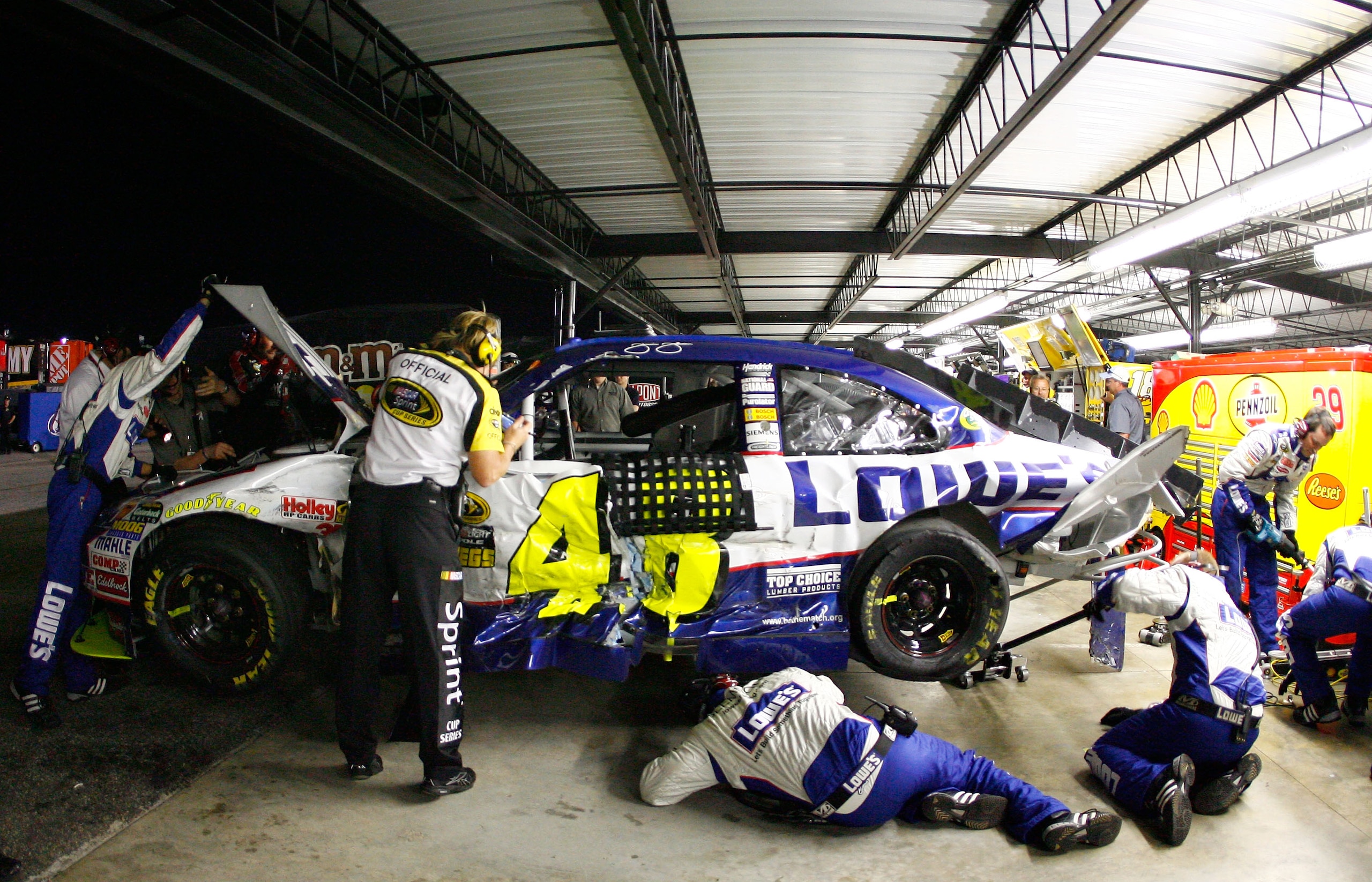 DARLINGTON, SC - MAY 08:  The crew of the #48 Lowe's Chevrolet, driven by Jimmie Johnson, works on the car in the garage after Johnson crashed during the NASCAR Sprint Cup series SHOWTIME Southern 500 at Darlington Raceway on May 8, 2010 in Darlington, So