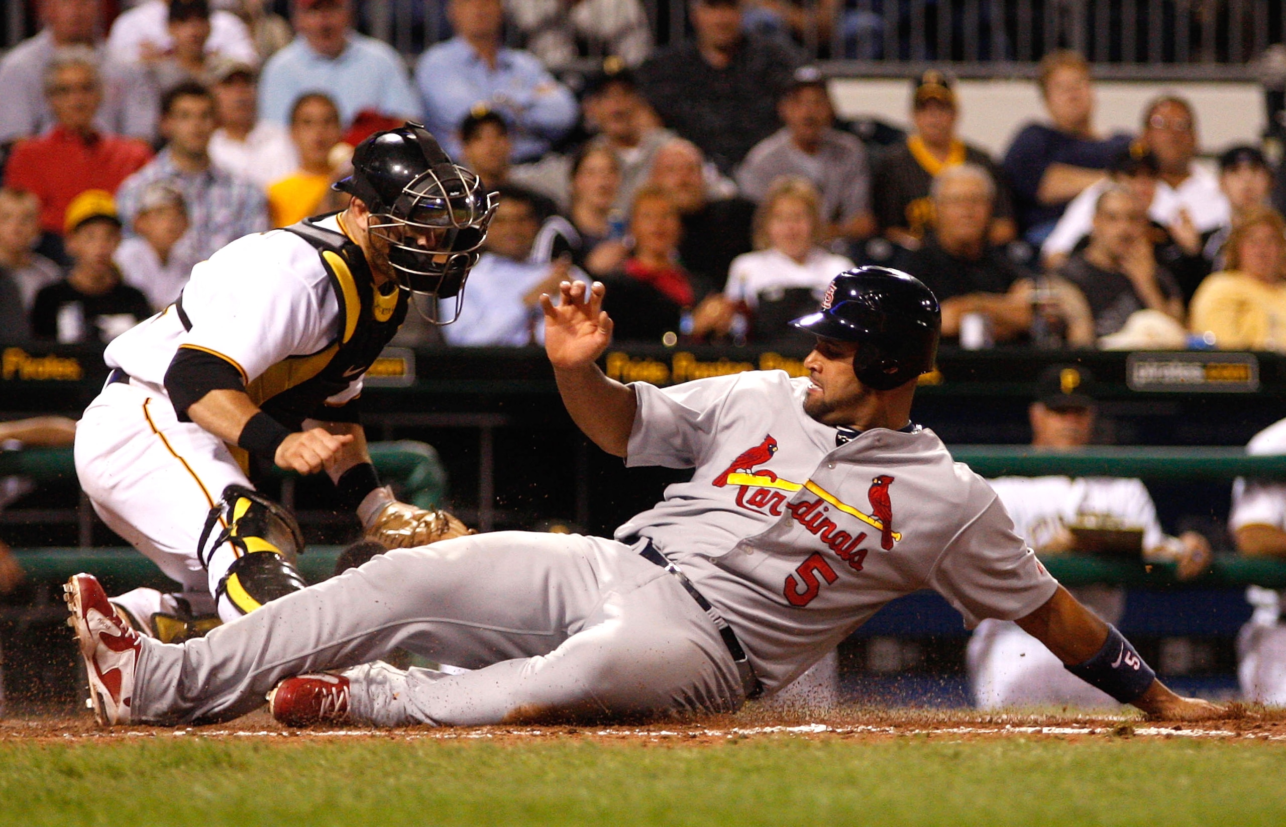 PITTSBURGH - AUGUST 23:  Albert Pujols #5 of the St Louis Cardinals slides safely and scores in front of Ryan Doumit #41 of the Pittsburgh Pirates during the game on August 23, 2010 at PNC Park in Pittsburgh, Pennsylvania.  (Photo by Jared Wickerham/Getty
