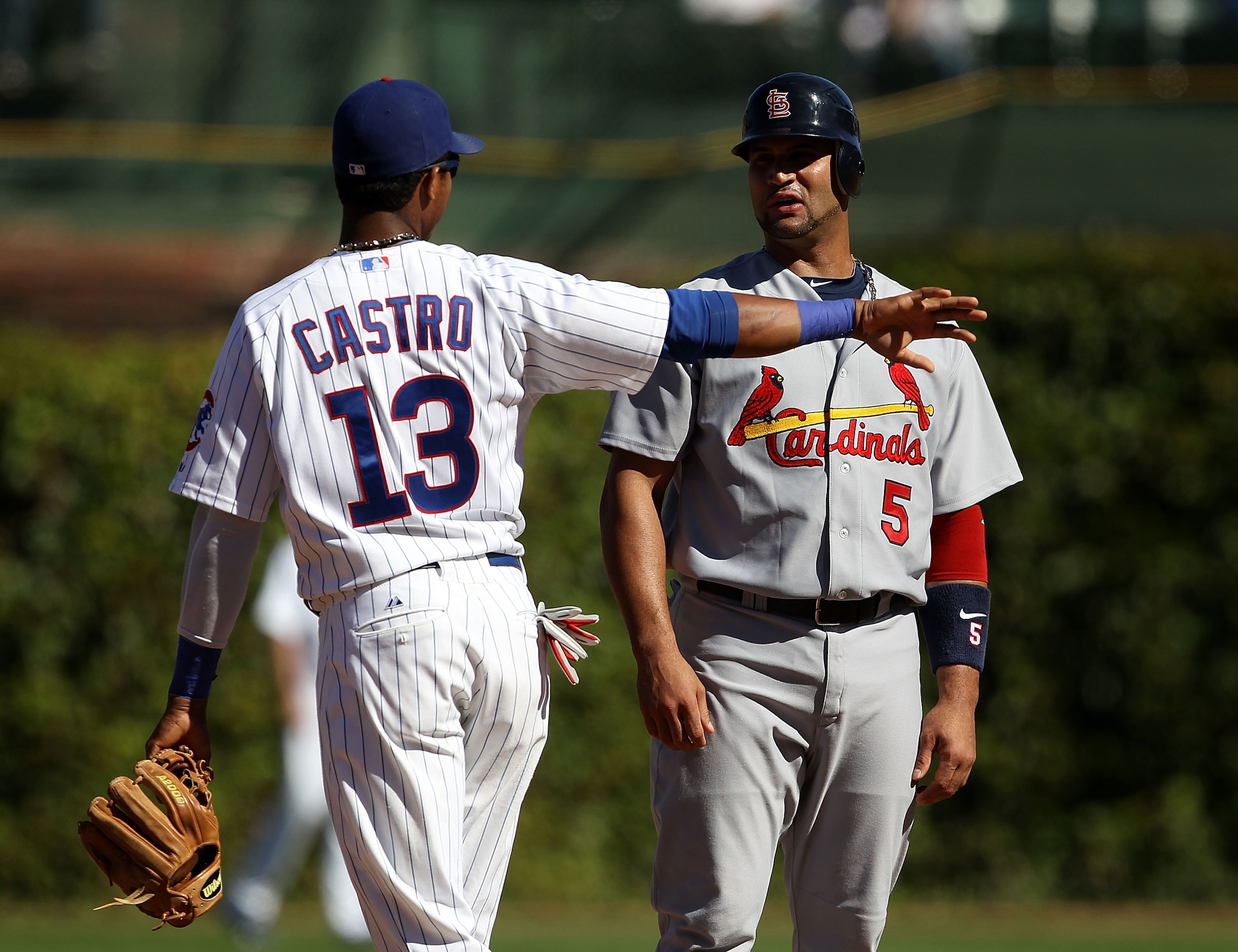 CHICAGO - SEPTEMBER 24: Starlin Castro #13 of the Chicago Cubs and Albert Pujols #5 of the St. Louis Cardinals have a conversation at second base during a pitching change at Wrigley Field on September 24, 2010 in Chicago, Illinois. (Photo by Jonathan Dani
