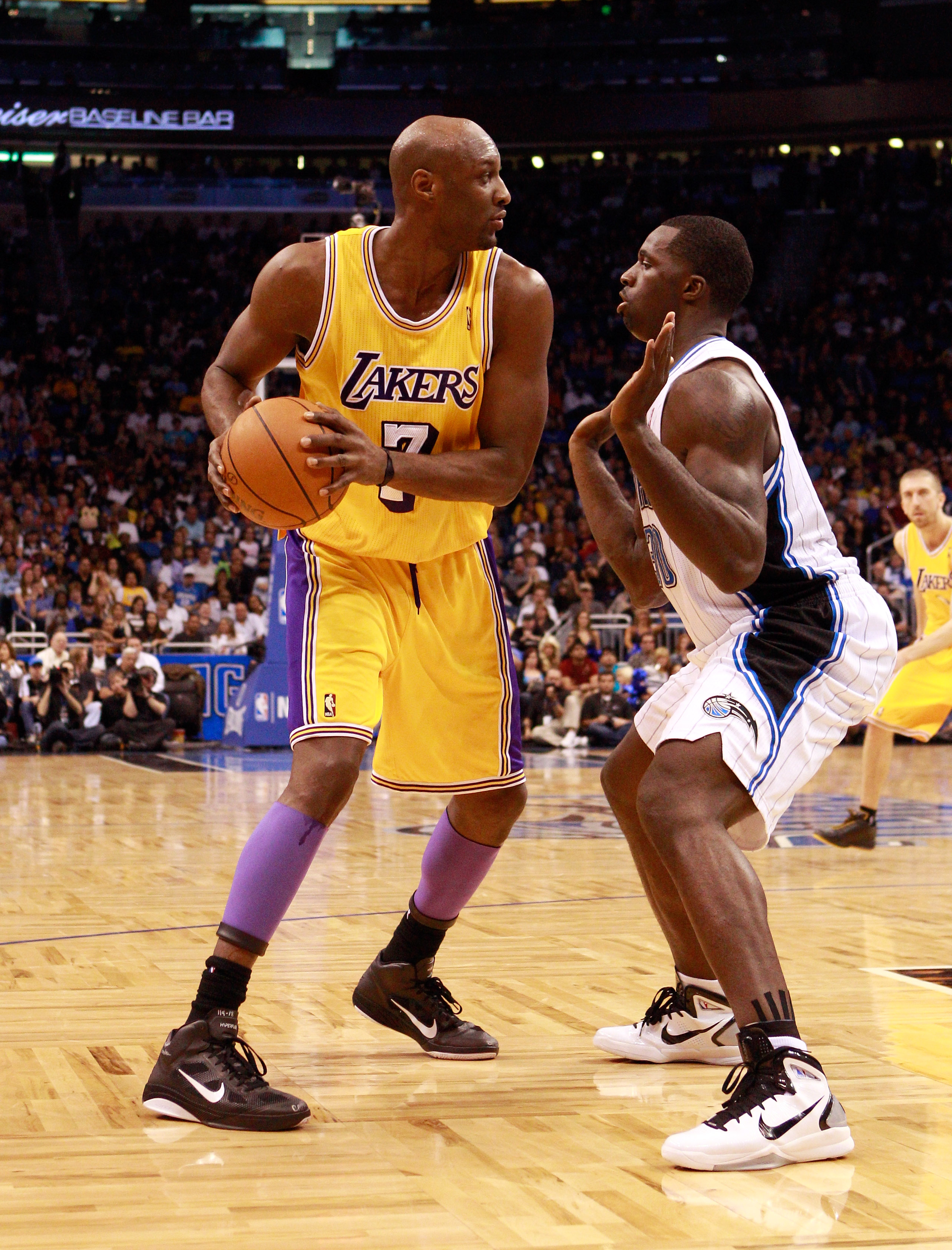 ORLANDO, FL - FEBRUARY 13:  Lamar Odom #7 of the Los Angeles Lakers is guarded by Brandon Bass #30 of the Orlando Magic during the game at Amway Arena on February 13, 2011 in Orlando, Florida.  NOTE TO USER: User expressly acknowledges and agrees that, by