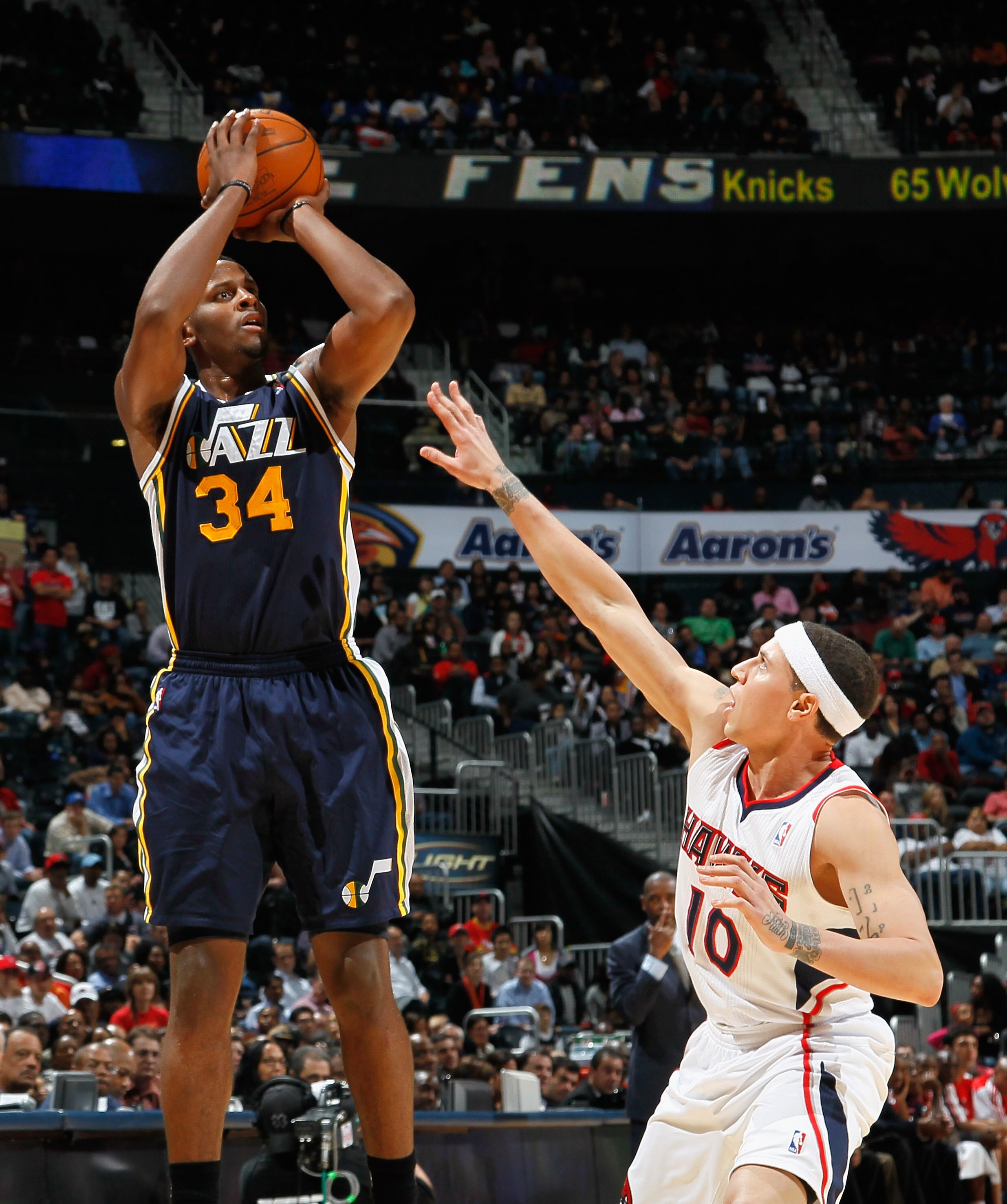 ATLANTA - NOVEMBER 12:  C.J. Miles #34 of the Utah Jazz against Mike Bibby #10 of the Atlanta Hawks at Philips Arena on November 12, 2010 in Atlanta, Georgia.  NOTE TO USER: User expressly acknowledges and agrees that, by downloading and/or using this Pho
