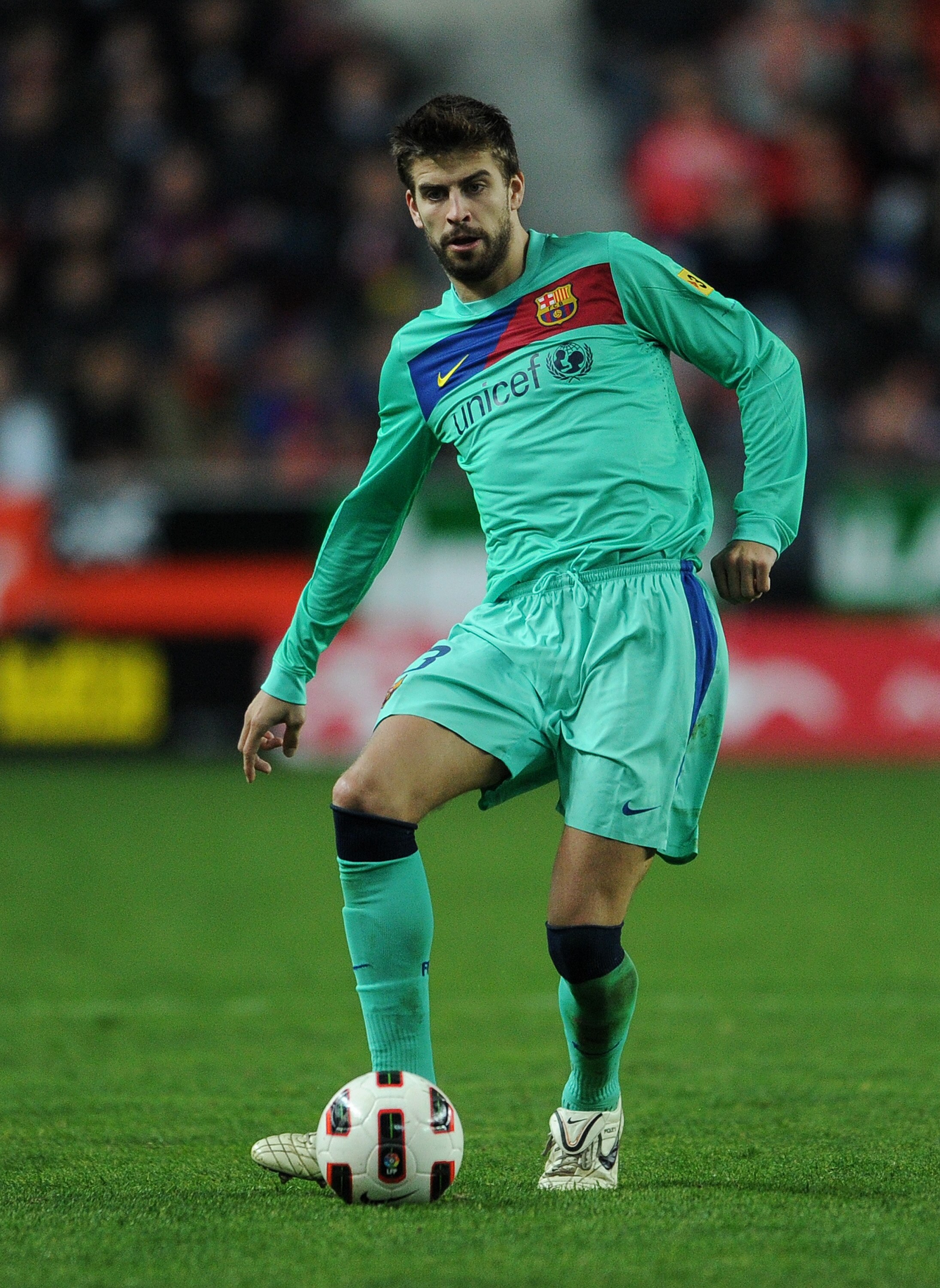 GIJON, SPAIN - FEBRUARY 12:  Gerard Pique of Barcelona strikes the ball during the la Liga match between Sporting Gijon and Barcelona at El Molinon Stadium on February 12, 2011 in Gijon, Spain.  (Photo by Jasper Juinen/Getty Images)