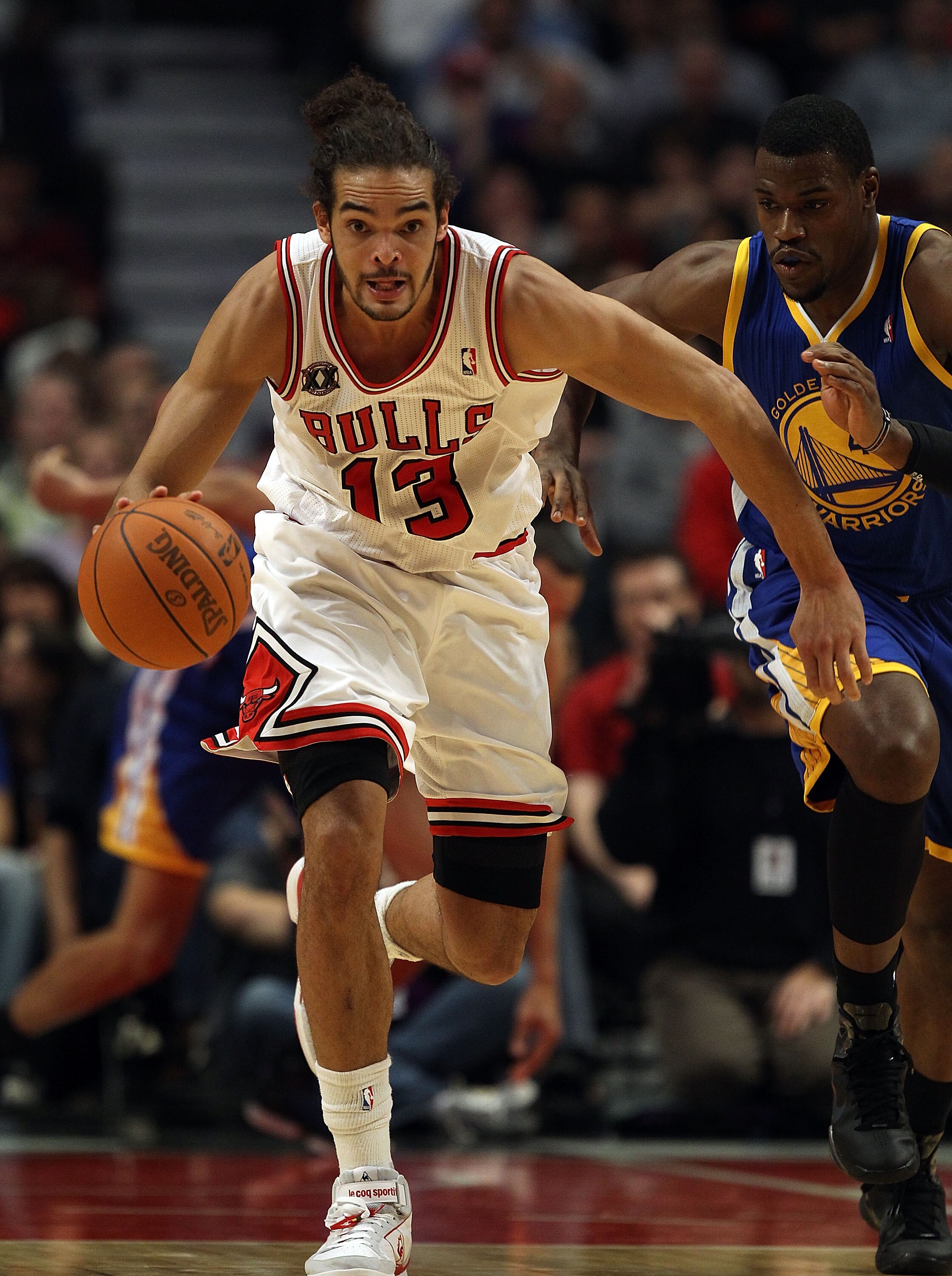 CHICAGO - NOVEMBER 11: Joakim Noah #13 of the Chicago Bulls breaks down court past Jeff Adrien #4 of the Golden State Warriors at the United Center on November 11, 2010 in Chicago, Illinois. The Bulls defeated the Warriors 120-90. NOTE TO USER: User expre
