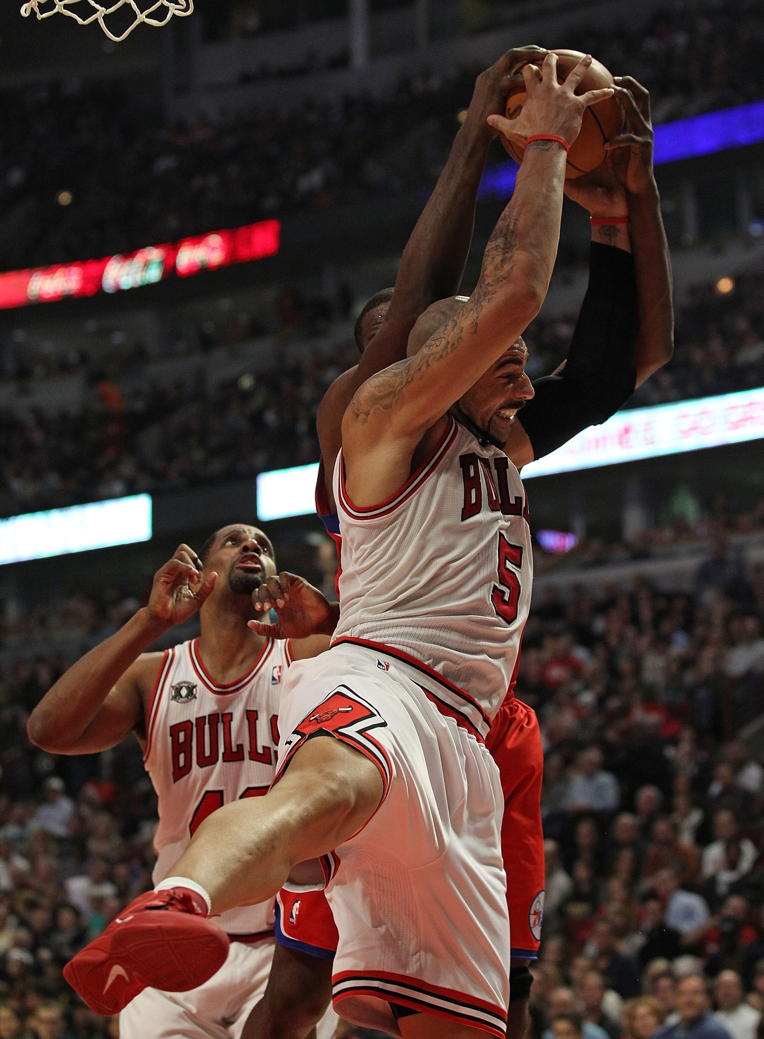 CHICAGO, IL - DECEMBER 21: Carlos Boozer #5 of the Chicago Bulls grabs a rebound from Elton Brand #42 of the Philadelphia 76ers at the United Center on December 21, 2010 in Chicago, Illinois. The Bulls defeated the 76ers 121-76. NOTE TO USER: User express