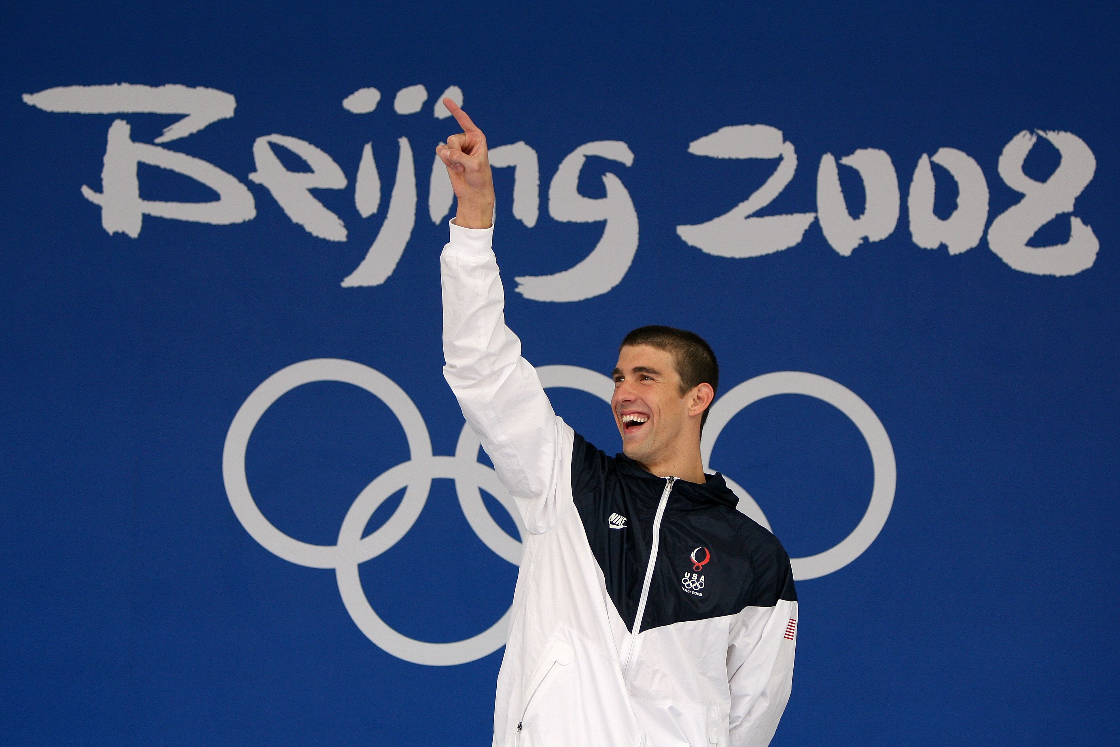 BEIJING - AUGUST 16:  Gold medalist Michael Phelps of the United States celebrates on the podium during the medal ceremony for the Men's 100m Butterfly Final held at the National Aquatics Centre during Day 8 of the Beijing 2008 Olympic Games on August 16,