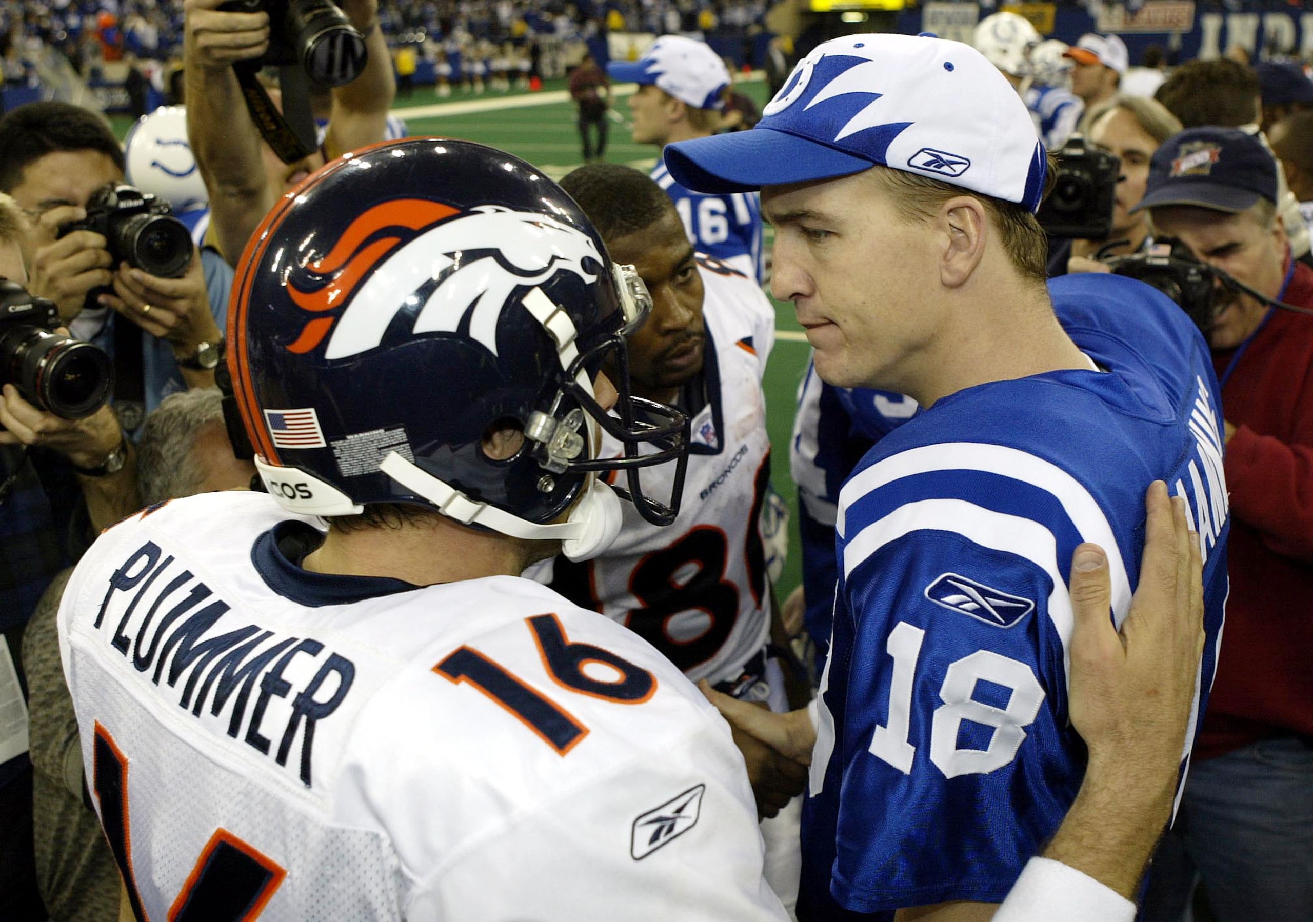 INDIANAPOLIS - JANUARY 4:  Quarterback Peyton Manning #18 of the Indianapolis Colts speaks to quarterback Jake Plummer #16 of the Denver Broncos during the AFC playoff game on January 4, 2004 at the RCA Dome in Indianapolis, Indiana. The Colts beat the Br
