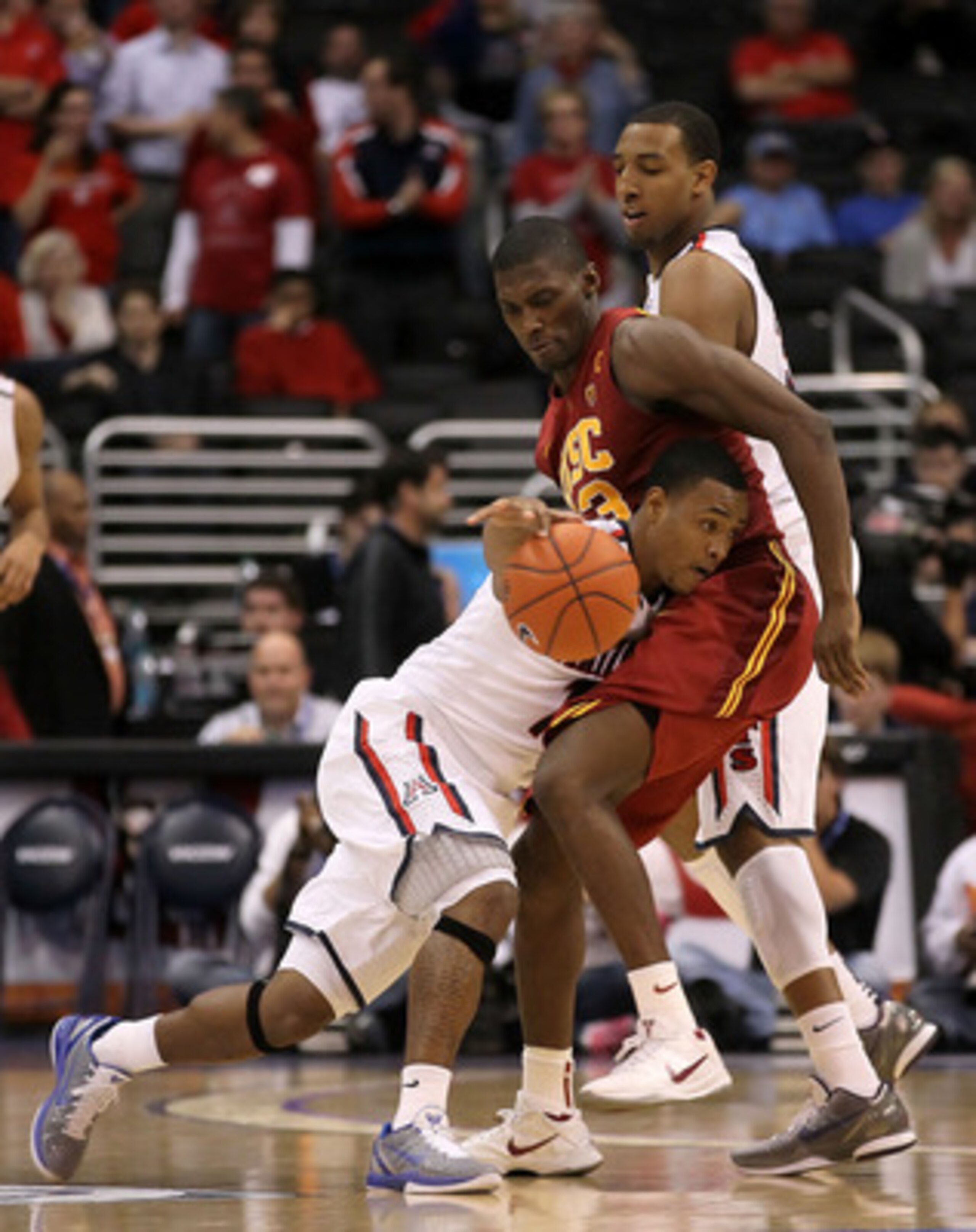LOS ANGELES, CA - MARCH 11:  Lamont Jones #12 of the Arizona Wildcats crashes into Marcus Simmons #43 of the USC Trojans in the second half in the semifinals of the 2011 Pacific Life Pac-10 Men's Basketball Tournament at Staples Center on March 11, 2011 i