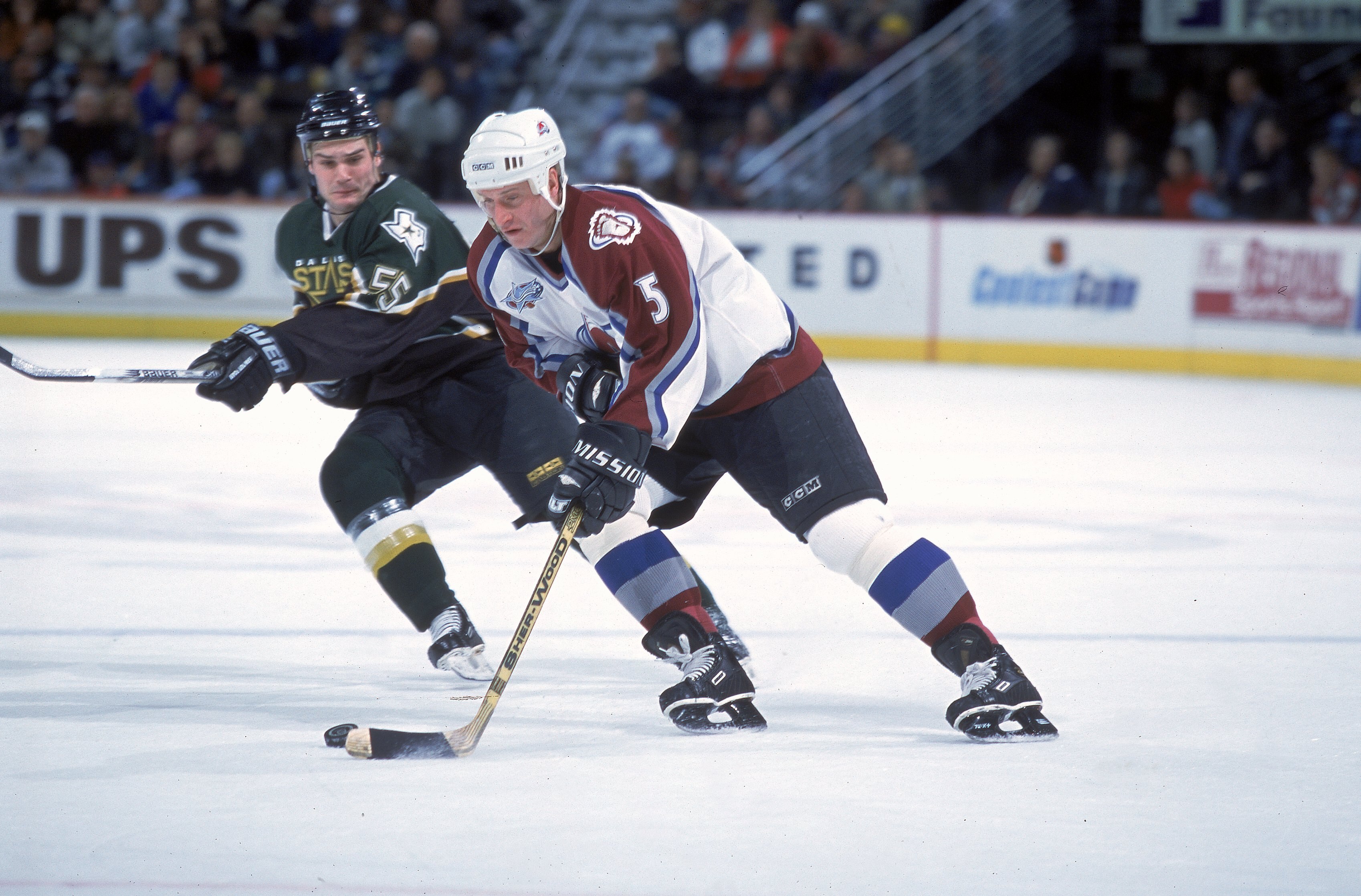 1 Dec 2000:  Alexei Gusarov #5 of the Colorado Avalanche controls the puck as Tyler Bouck #55 of the Dallas Stars moves in at the Pepsi Center in Denver, Colorado. The Avelanche defeated the Stars 4-2.Mandatory Credit: Brian Bahr  /Allsport