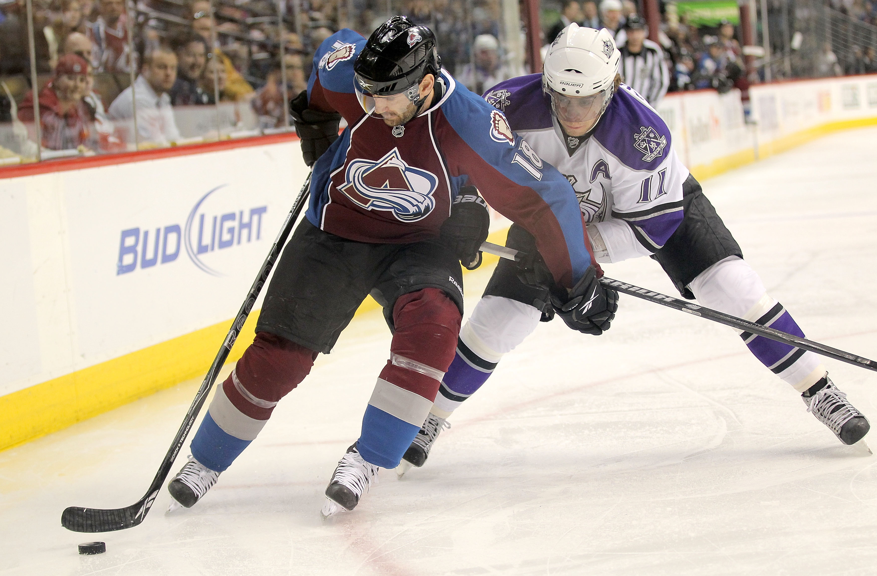 DENVER - APRIL 11:  Stephane Yelle #18 of the Colorado Avalanche controls the puck as Anze Kopitar #11 of the Los Angeles Kings applies pressure during NHL action at the Pepsi Center on April 11, 2010 in Denver, Colorado.  (Photo by Doug Pensinger/Getty I