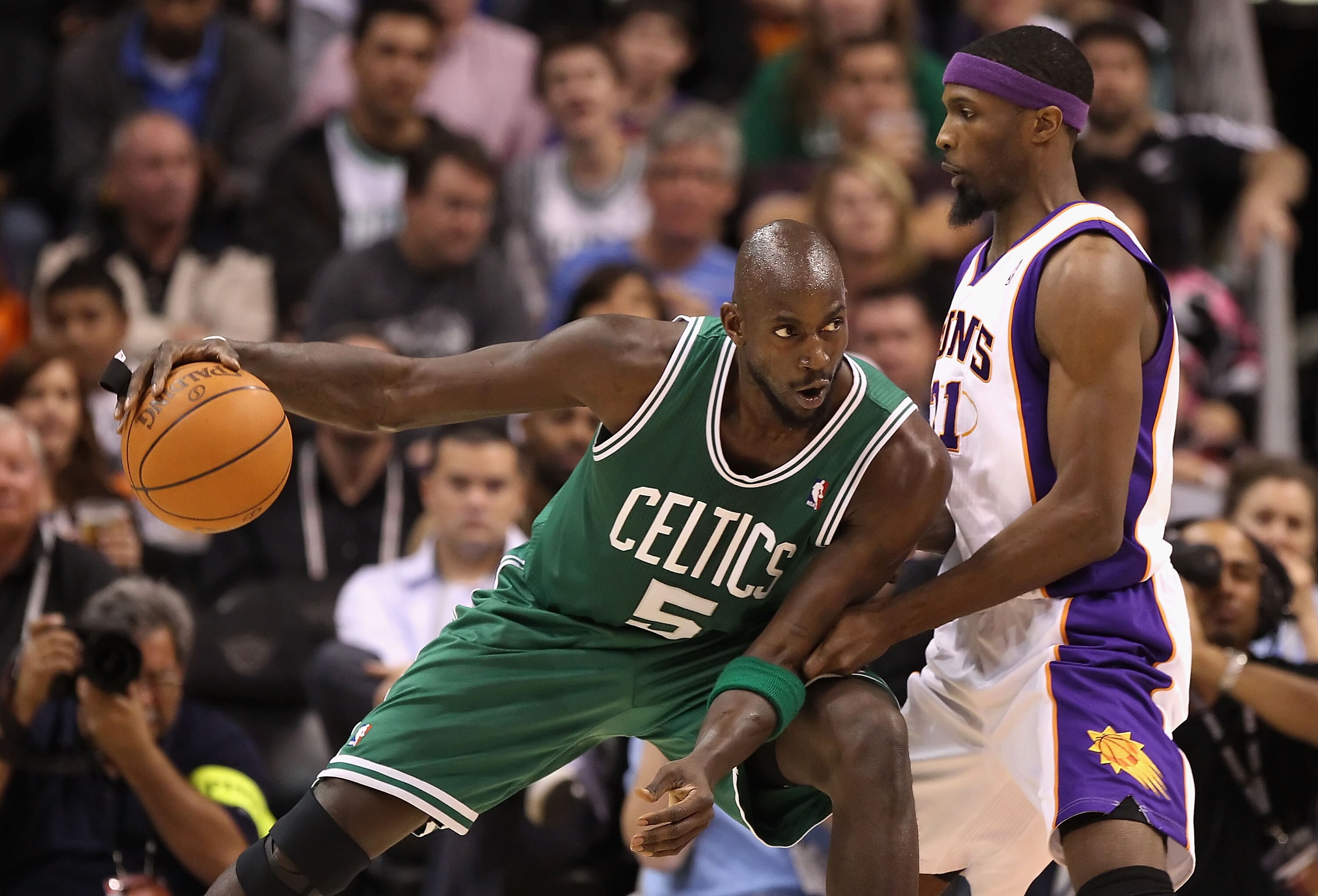 PHOENIX, AZ - JANUARY 28:  Kevin Garnett #5 of the Boston Celtics handles the ball guarded by Hakim Warrick #21 of the Phoenix Suns during the NBA game at US Airways Center on January 28, 2011 in Phoenix, Arizona.  The Suns defeated the Celtics 88-71.  NO