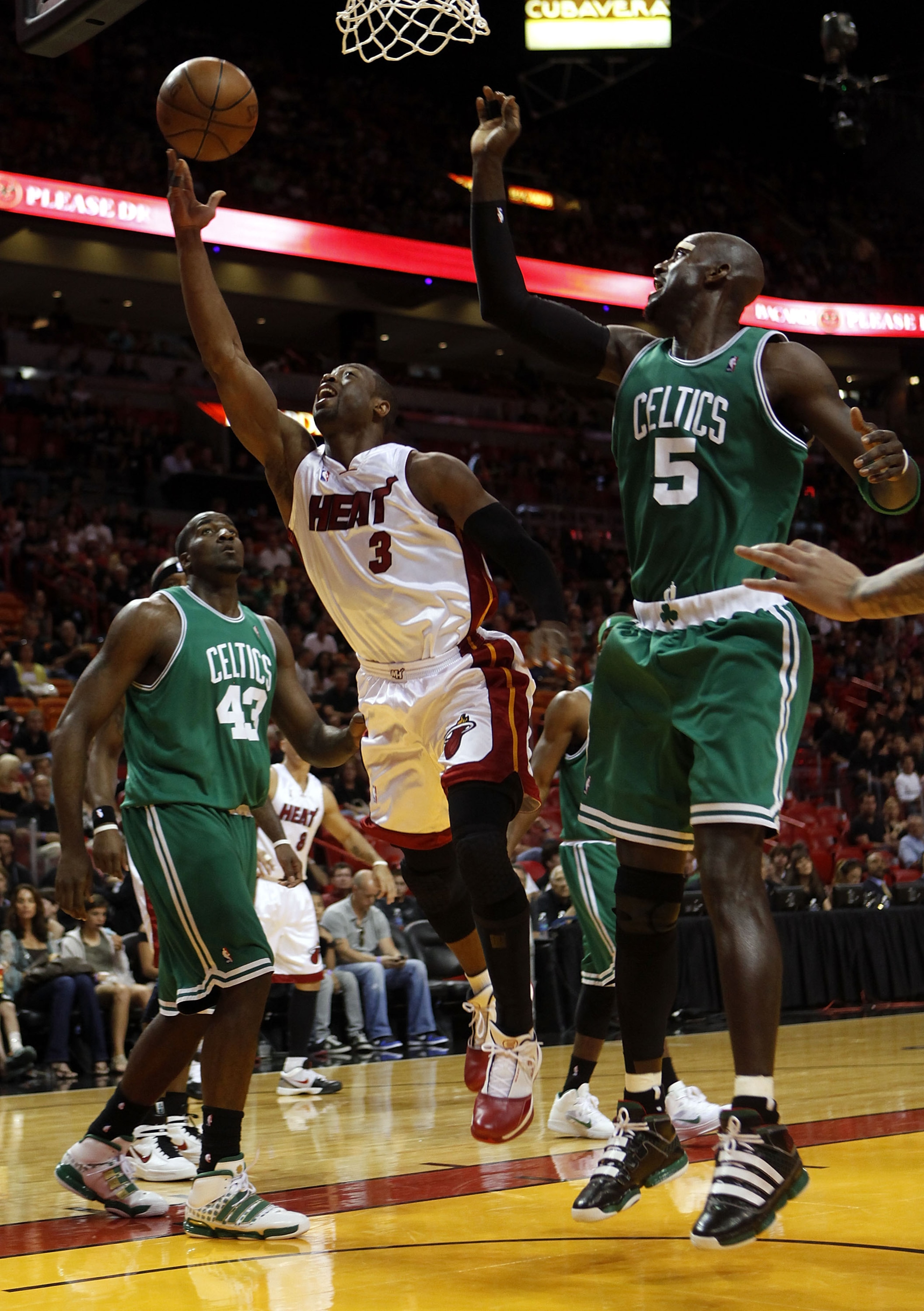 MIAMI - APRIL 25:  Guard Dwyane Wade #3 of the Miami Heat scores against Center Kendrick Perkins #43 and Forward Kevin Garnett #5 of the Boston Celtics in Game Four of the Eastern Conference Quarterfinals during the 2010 NBA Playoffs at American Airlines 