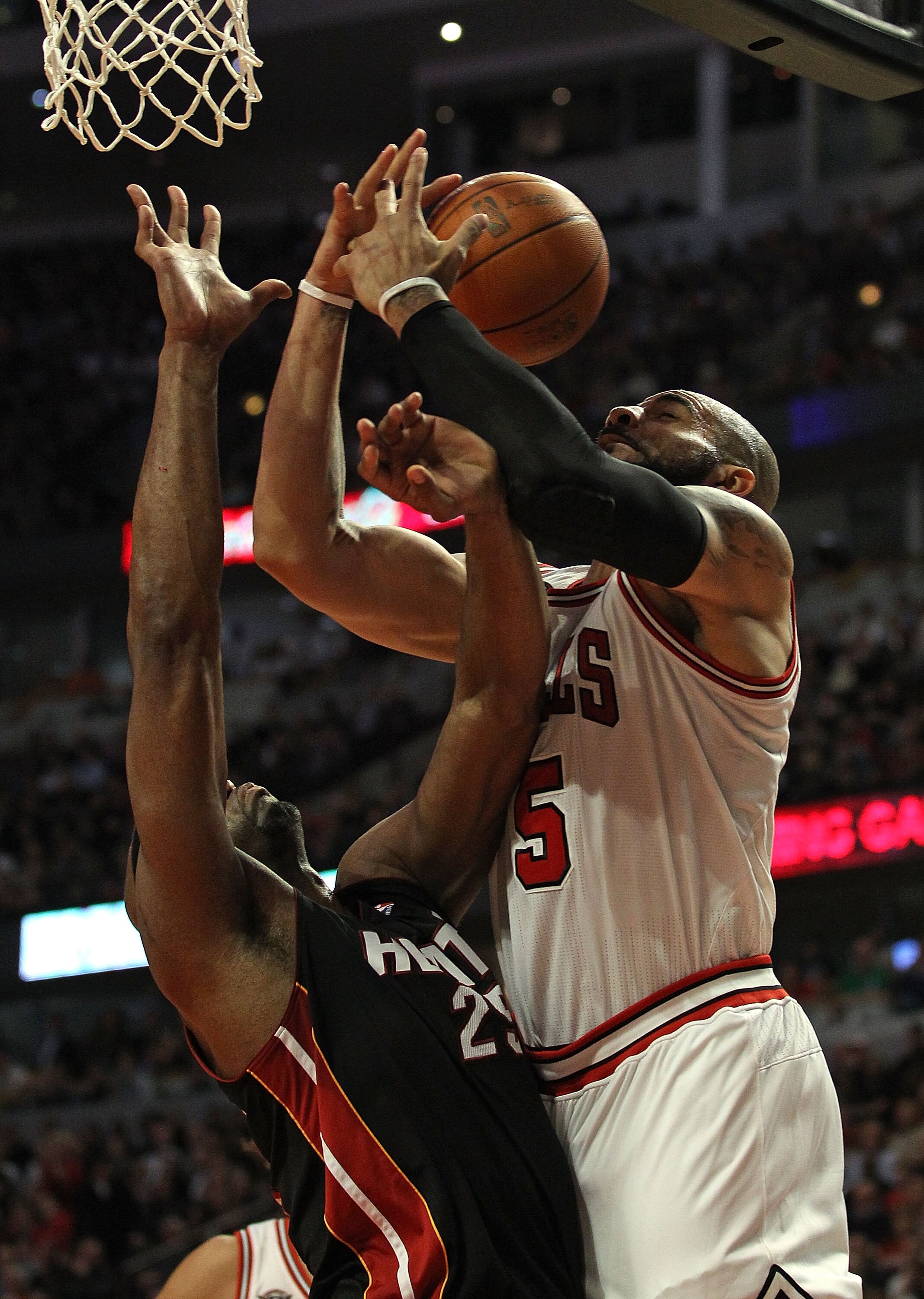 CHICAGO, IL - FEBRUARY 24: Carlos Boozer #5 of the Chicago Bulls is fouled while shooting by Eric Dampier #25 of the Miami Heat at the United Center on February 24, 2011 in Chicago, Illinois. The Bulls defeated the Heat 93-89. NOTE TO USER: User expressly