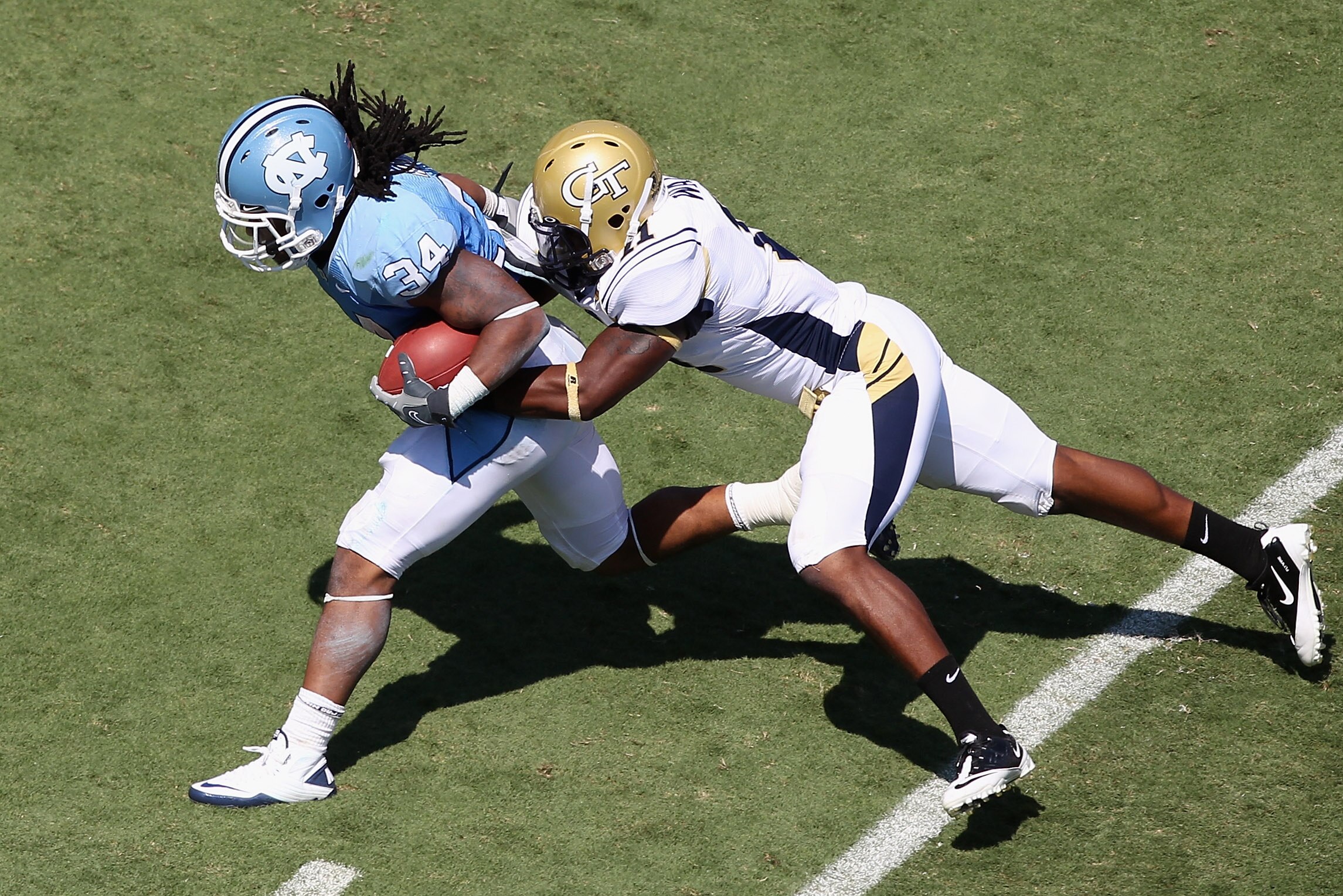 CHAPEL HILL, NC - SEPTEMBER 18:  Brandon Watts #11 of the Georgia Tech Yellow Jackets tackles Johnny White #34 of the North Carolina Tar Heels during their game at Kenan Stadium on September 18, 2010 in Chapel Hill, North Carolina.  (Photo by Streeter Lec