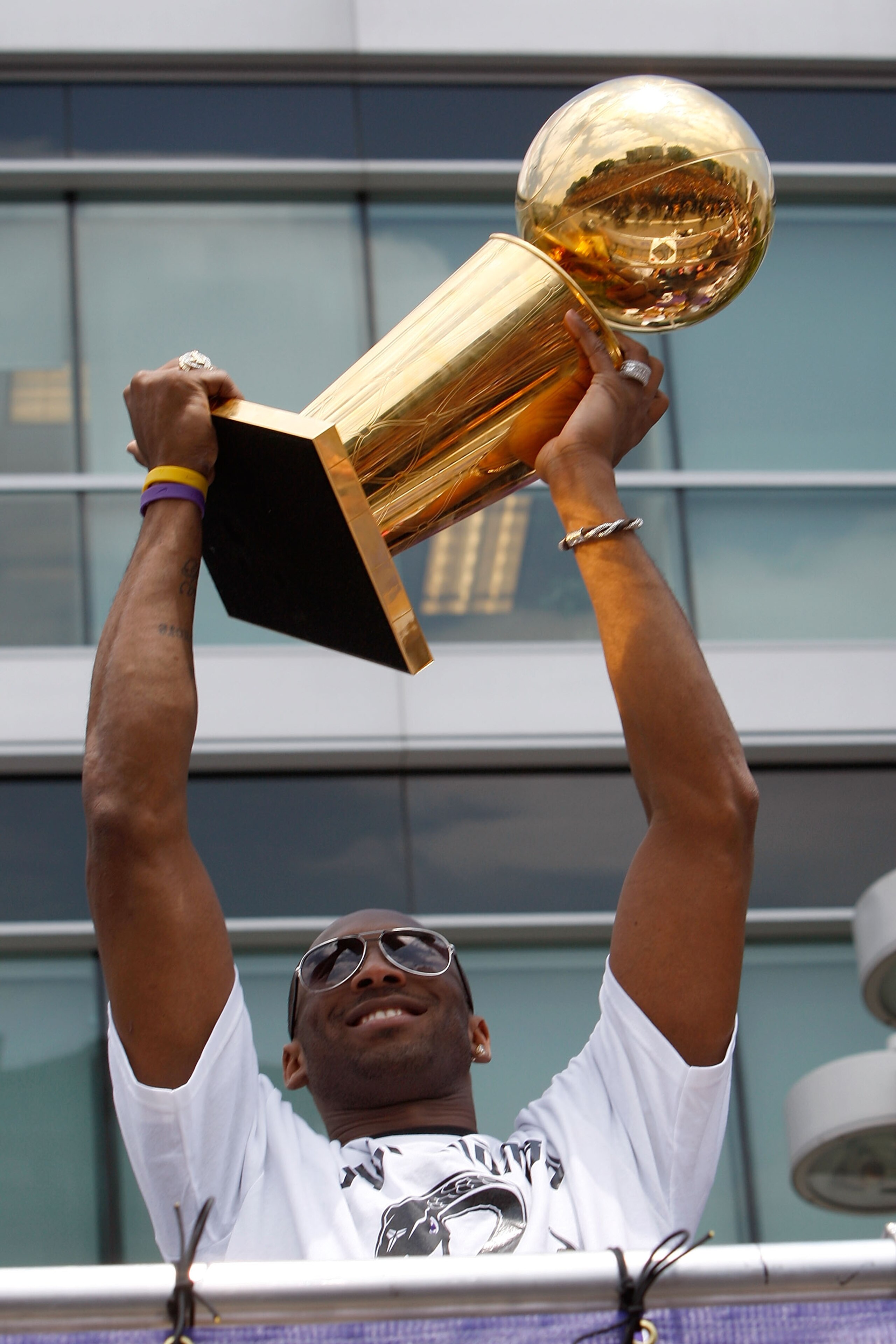 LOS ANGELES, CA - JUNE 21: Los Angeles Lakers guard Kobe Bryant hoists the championship trophy while riding in the victory parade for the the NBA basketball champion team on June 21, 2010 in Los Angeles, California. The Lakers beat the Boston Celtics 87- LOS ANGELES, CA - JUNE 21: Los Angeles Lakers guard Kobe Bryant hoists the championship trophy while riding in the victory parade for the the NBA basketball champion team on June 21, 2010 in Los Angeles, California. The Lakers beat the Boston Celtics 87-