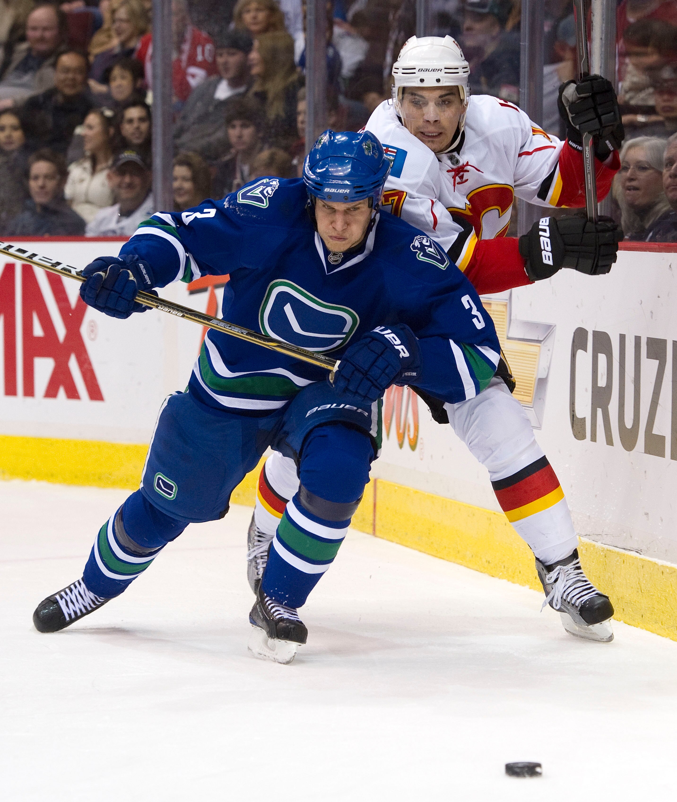 VANCOUVER, CANADA - FEBRUARY 12: Kevin Bieksa #3 of the Vancouver Canucks gets position on Rene Bourque #17 of the Calgary Flames as they battle for the loose puck during the first period in NHL action on February 12, 2011 at Rogers Arena in Vancouver, Br