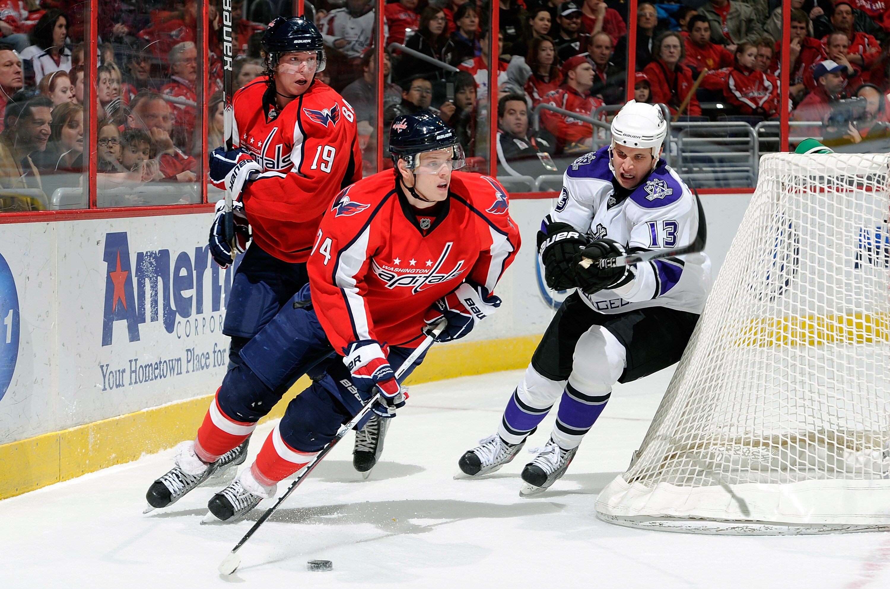 WASHINGTON, DC - FEBRUARY 12:  John Carlson #74 of the Washington Capitals brings the puck around the net against Kyle Clifford #13 of the Los Angeles Kings at the Verizon Center on February 12, 2011 in Washington, DC.  (Photo by Greg Fiume/Getty Images)
