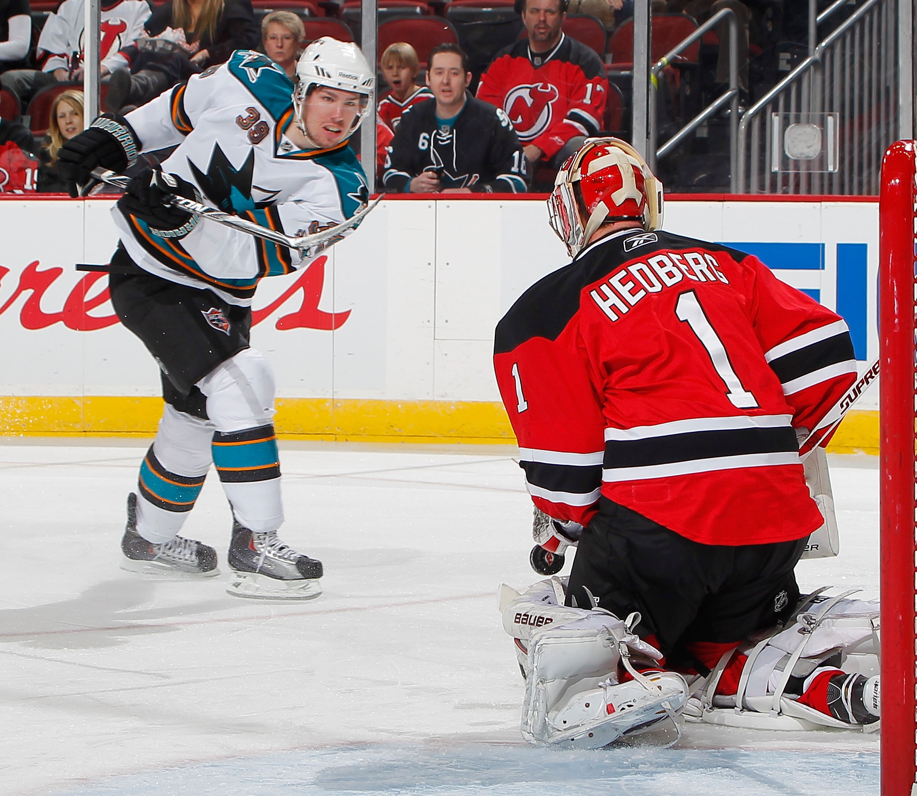 NEWARK, NJ - FEBRUARY 11:  Logan Couture #39 of the San Jose Sharks shoots on goal as Goalie Johan Hedberg #1 of the New Jersey Devils stops the puck during the first period of an NHL hockey game on February 11, 2011 at the Prudential Center in Newark, Ne