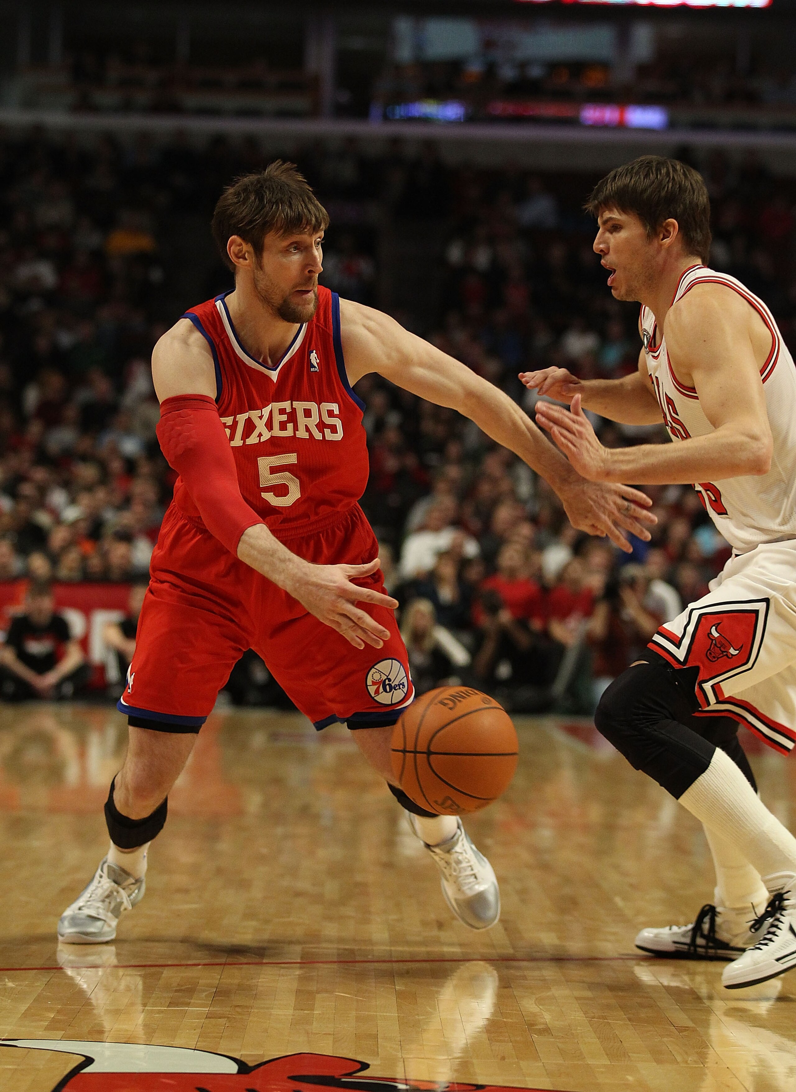 CHICAGO, IL - DECEMBER 21: Andres Nocioni #5 of the Philadelphia 76ers passes the ball around Kyle Korver #26 of the Chicago Bulls at the United Center on December 21, 2010 in Chicago, Illinois. The Bulls defeated the 76ers 121-76. NOTE TO USER: User expr CHICAGO, IL - DECEMBER 21: Andres Nocioni #5 of the Philadelphia 76ers passes the ball around Kyle Korver #26 of the Chicago Bulls at the United Center on December 21, 2010 in Chicago, Illinois. The Bulls defeated the 76ers 121-76. NOTE TO USER: User expr