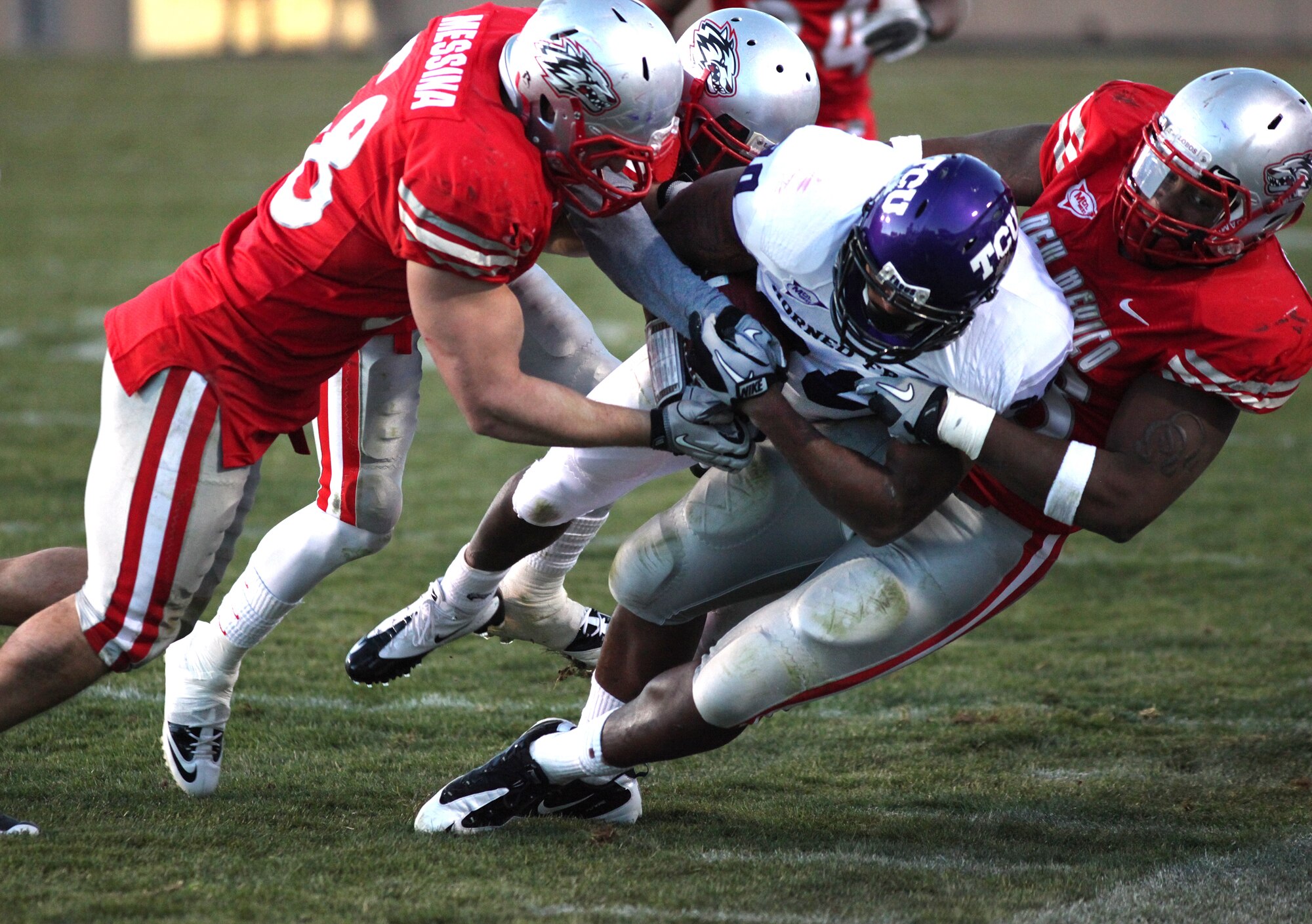 ALBUQUERQUE, NM - NOVEMBER 27: Aundre Dean #30 of the TCU Horned Frogs carries the ball against Carmen Messina #58 (L) and Jaymar Latchison #48 of the New Mexico Lobos in the 3rd quarter on November 27, 2010 at University Stadium in Albuquerque, New Mexic