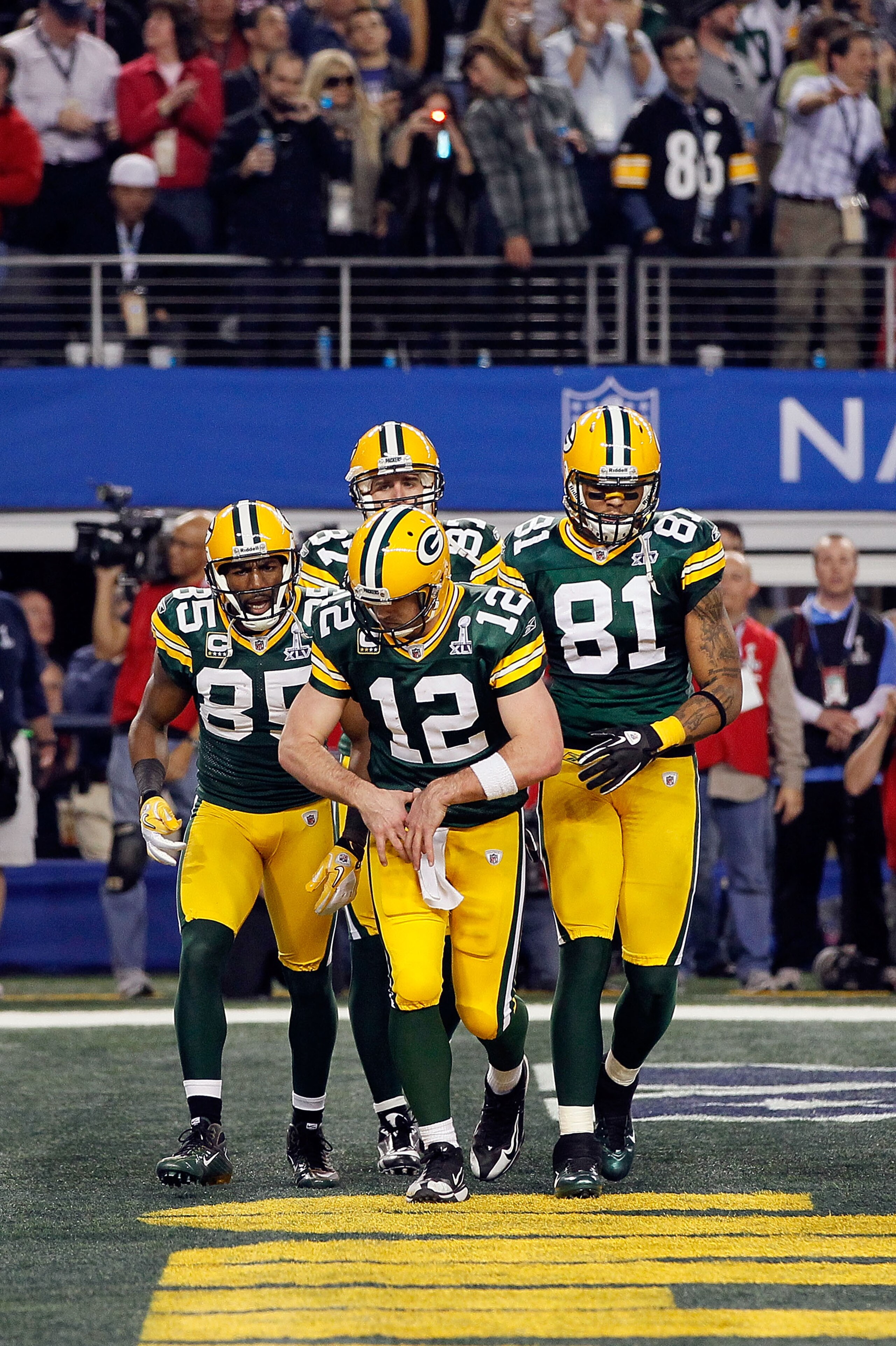 ARLINGTON, TX - FEBRUARY 06: Aaron Rodgers #12 of the Green Bay Packers gestures putting on a championship belt as he celebrates a Green Bay touchdown against the Pittsburgh Steelers during Super Bowl XLV at Cowboys Stadium on February 6, 2011 in Arlingt ARLINGTON, TX - FEBRUARY 06: Aaron Rodgers #12 of the Green Bay Packers gestures putting on a championship belt as he celebrates a Green Bay touchdown against the Pittsburgh Steelers during Super Bowl XLV at Cowboys Stadium on February 6, 2011 in Arlingt