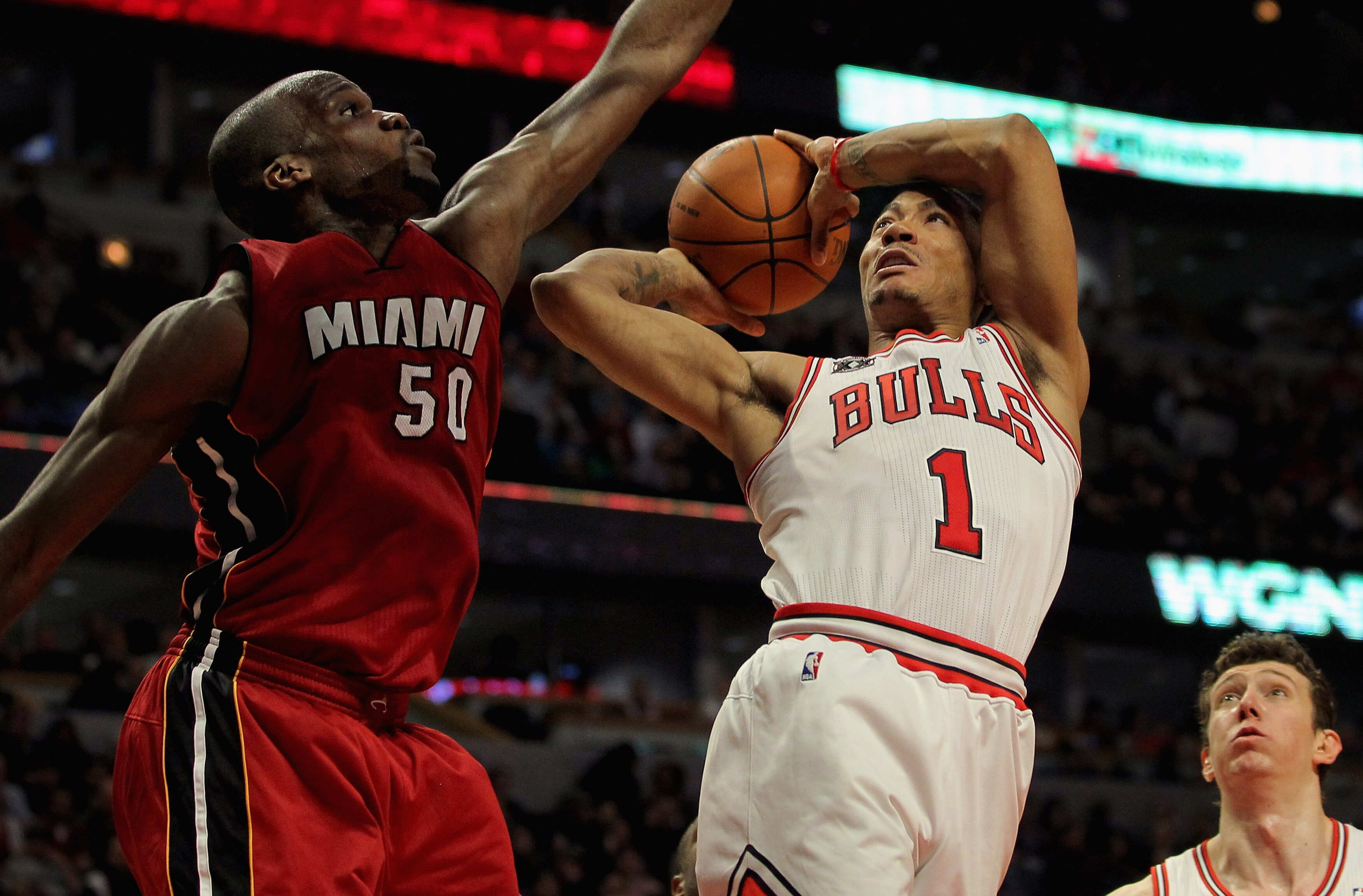 CHICAGO, IL - JANUARY 15:  Derrick Rose #1 of the Chicago Bulls gets off a shot as he is fouled by Joel Anthony #50 of the Miami Heat at the United Center on January 15, 2011 in Chicago, Illinois. NOTE TO USER: User expressly acknowledges and agrees that,