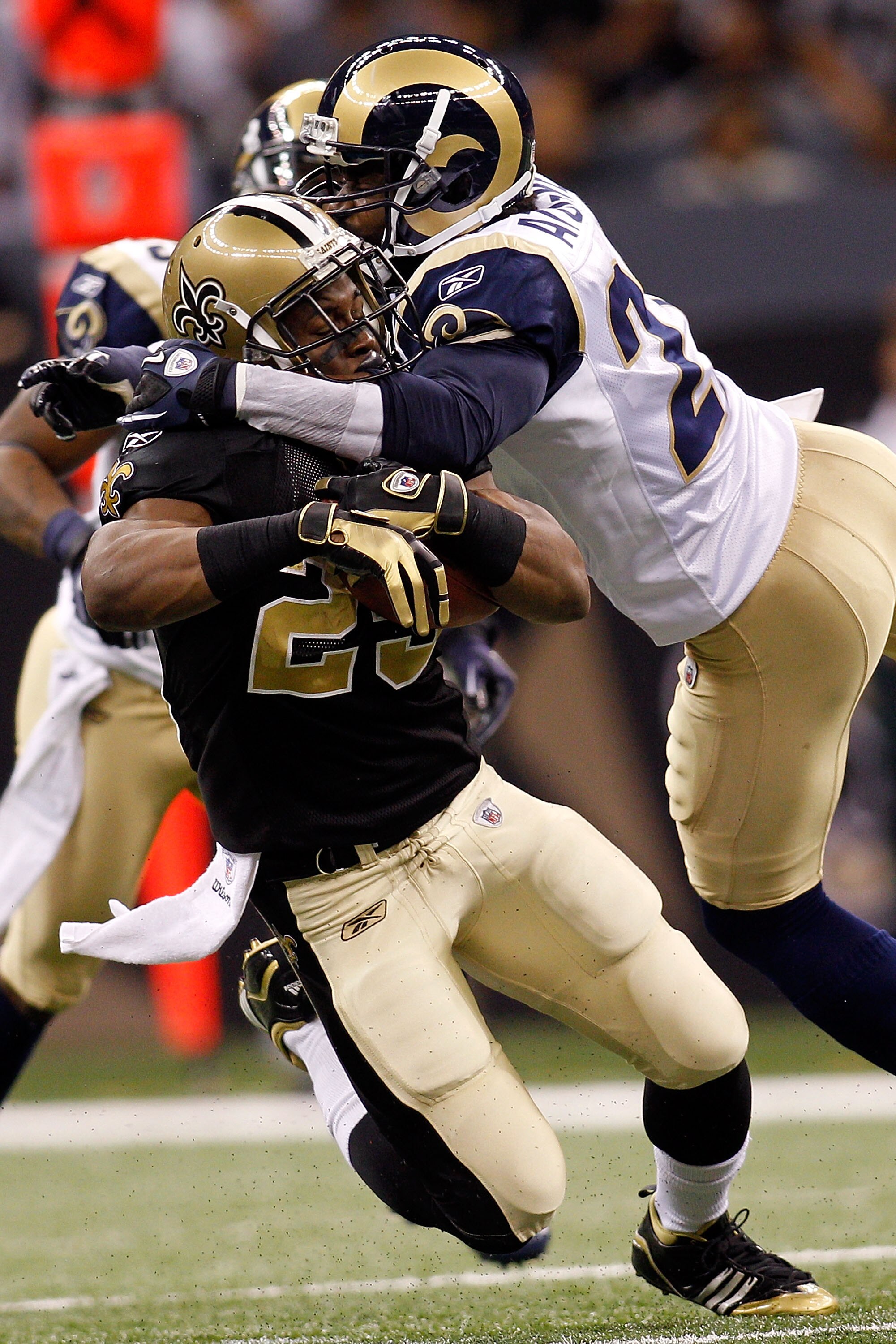 NEW ORLEANS, LA - DECEMBER 12:  Pierre Thomas #23 of the New Orleans Saints is tackled by Oshiomogho Atogwe #21 of the St. Louis Rams at the Louisiana Superdome on December 12, 2010 in New Orleans, Louisiana.  (Photo by Chris Graythen/Getty Images)