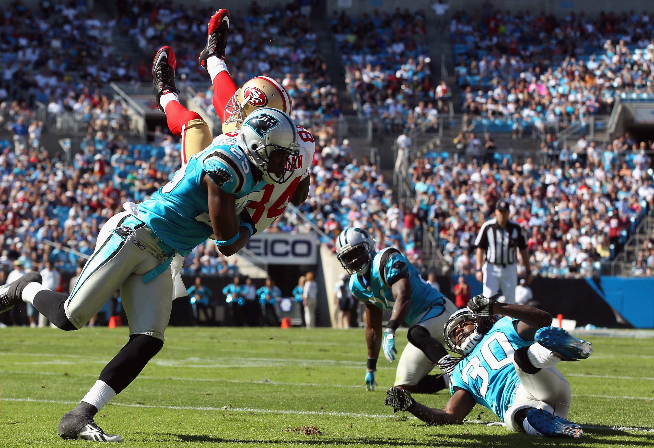 CHARLOTTE, NC - OCTOBER 24:  Josh Morgan #84 of the San Francisco 49ers is tackled by Marcus Hudson #25 of the Carolina Panthers during their game at Bank of America Stadium on October 24, 2010 in Charlotte, North Carolina.  (Photo by Streeter Lecka/Getty