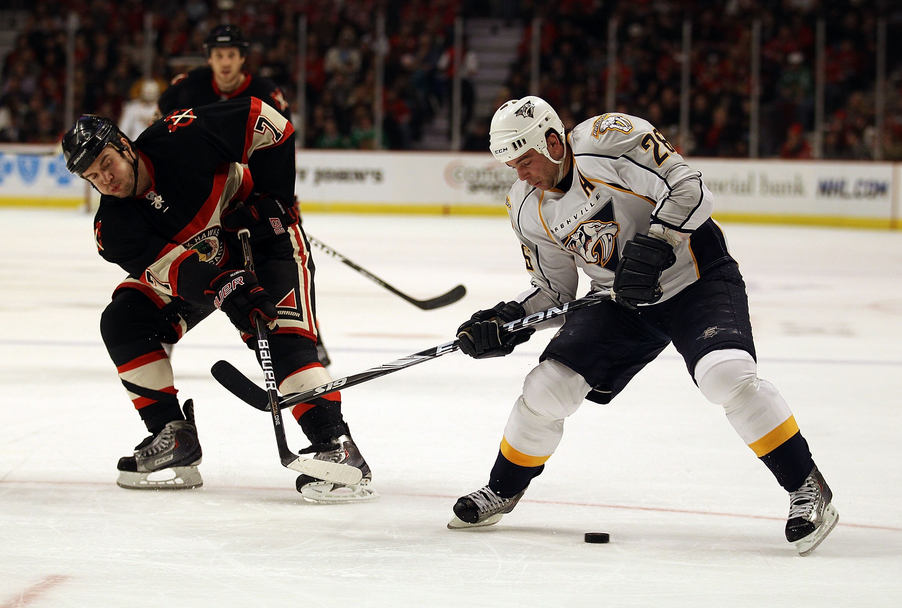 CHICAGO, IL - DECEMBER 22: Steve Sullivan #26 of the Nashville Predators tries to control the puck under pressure from Brent Seabrook #7 of the Chicago Blackhawks at the United Center on December 22, 2010 in Chicago, Illinois. The Blackhawks defeated the