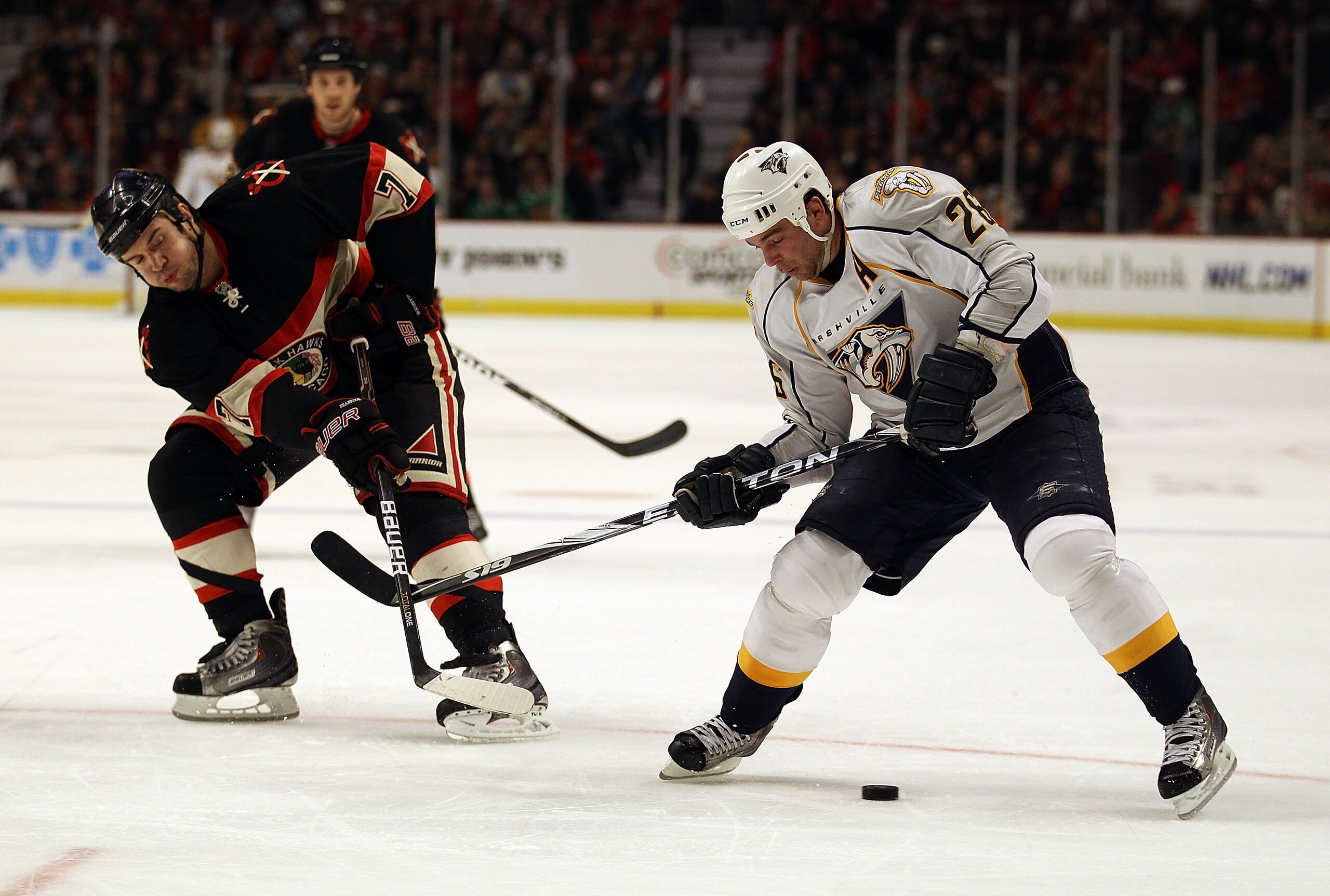 CHICAGO, IL - DECEMBER 22: Steve Sullivan #26 of the Nashville Predators tries to control the puck under pressure from Brent Seabrook #7 of the Chicago Blackhawks at the United Center on December 22, 2010 in Chicago, Illinois. The Blackhawks defeated the