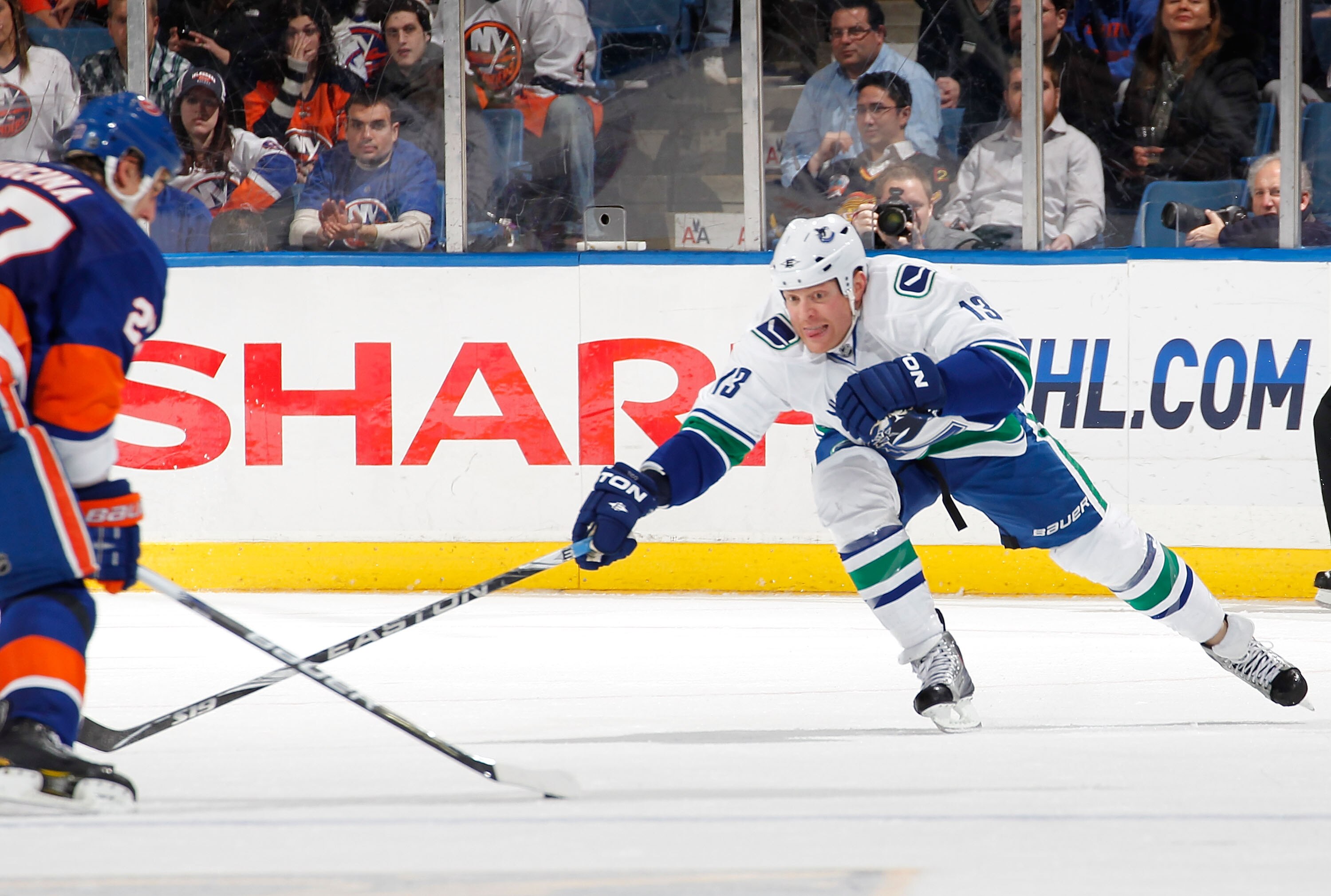 UNIONDALE, NY - JANUARY 11:  Raffi Torres #13 of the Vancouver Canucks tries to poke check the puck during an NHL game against the New York Islanders at Nassau Coliseum on January 11, 2011 in Uniondale, New York.  (Photo by Paul Bereswill/Getty Images)