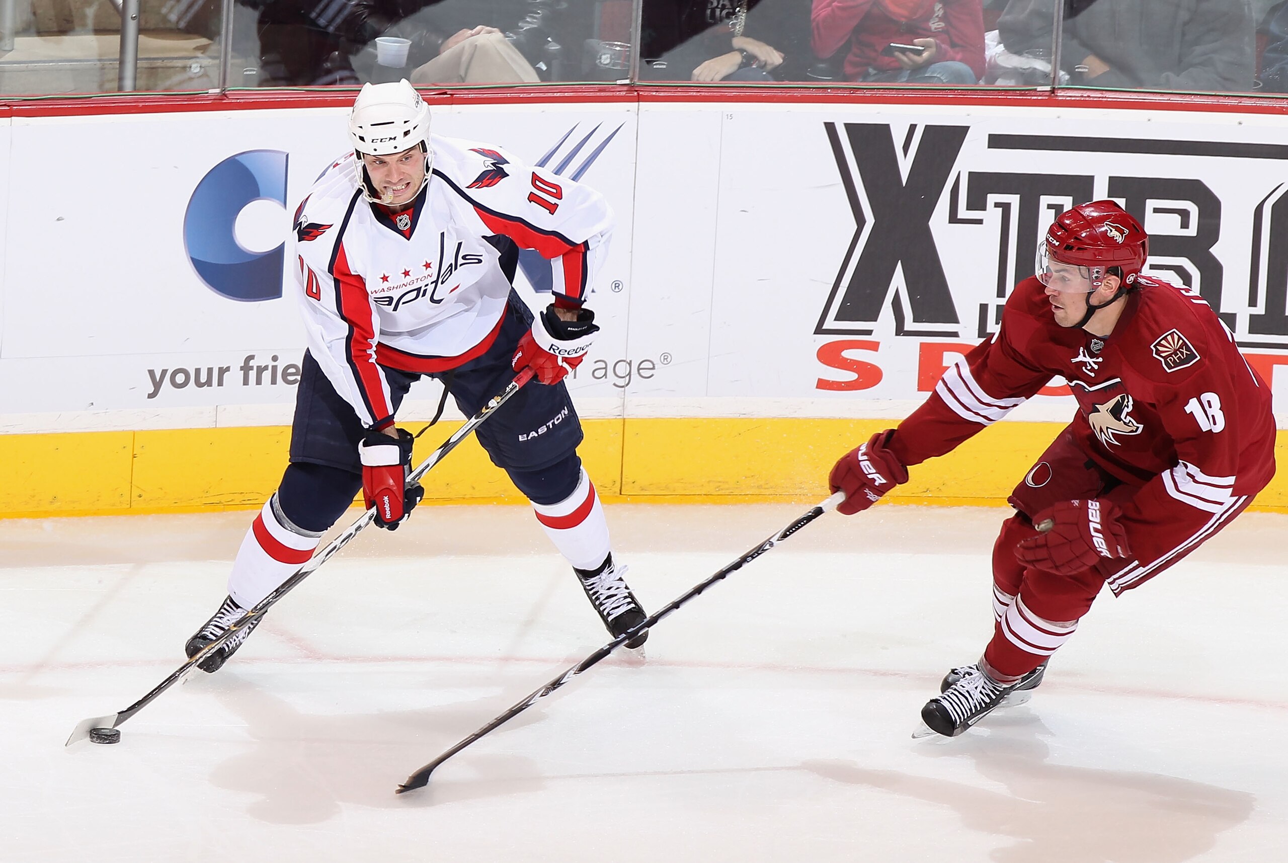 GLENDALE, AZ - FEBRUARY 14:  Matt Bradley #10 of the Washington Capitals looks to pass the puck under pressure from Sami Lepisto #18 of the Phoenix Coyotes during the NHL game at Jobing.com Arena on February 14, 2011 in Glendale, Arizona.  (Photo by Chris