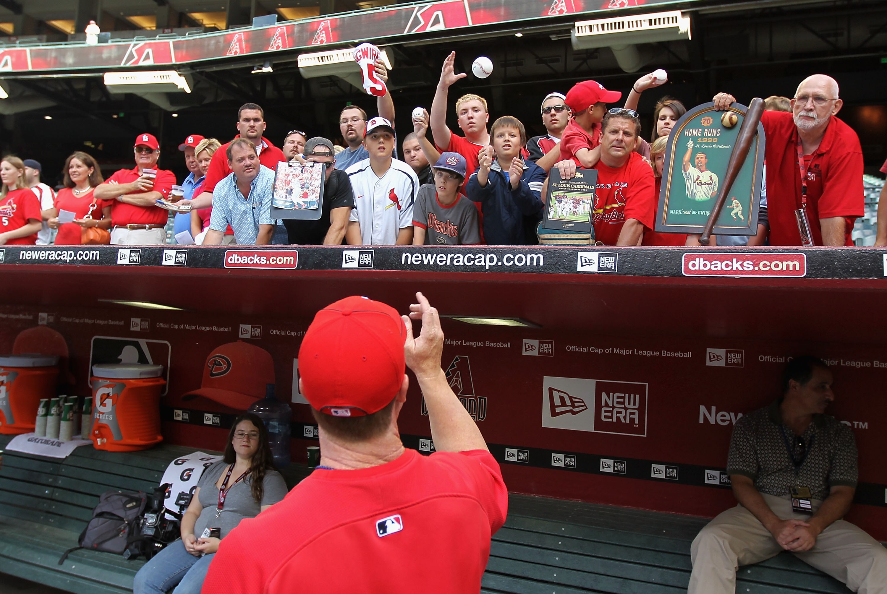PHOENIX - APRIL 19:  Batting coach Mark McGwire #25 of the St. Louis Cardinals signs autographs for fans before the Major League Baseball game against the Arizona Diamondbacks at Chase Field on April 19, 2010 in Phoenix, Arizona.  (Photo by Christian Pete
