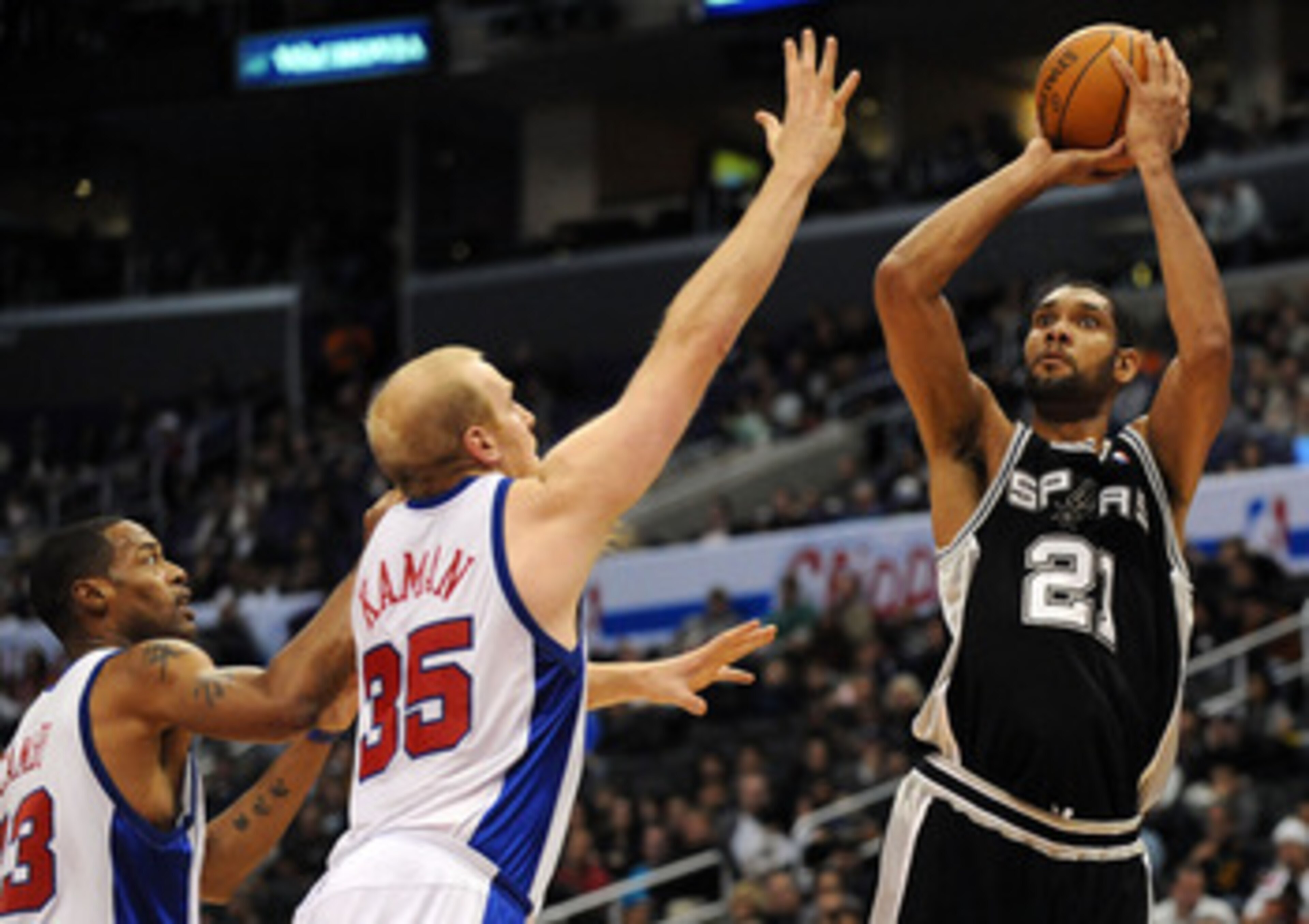 LOS ANGELES, CA - DECEMBER 13:  Tim Duncan #21 of the San Antonio Spurs shoots a jumper over Chris Kaman #35 and Marcus Camby #23 of the Los Angeles Clippers during the game at Staples Center on December 13, 2009 in Los Angeles, California.  NOTE TO USER: