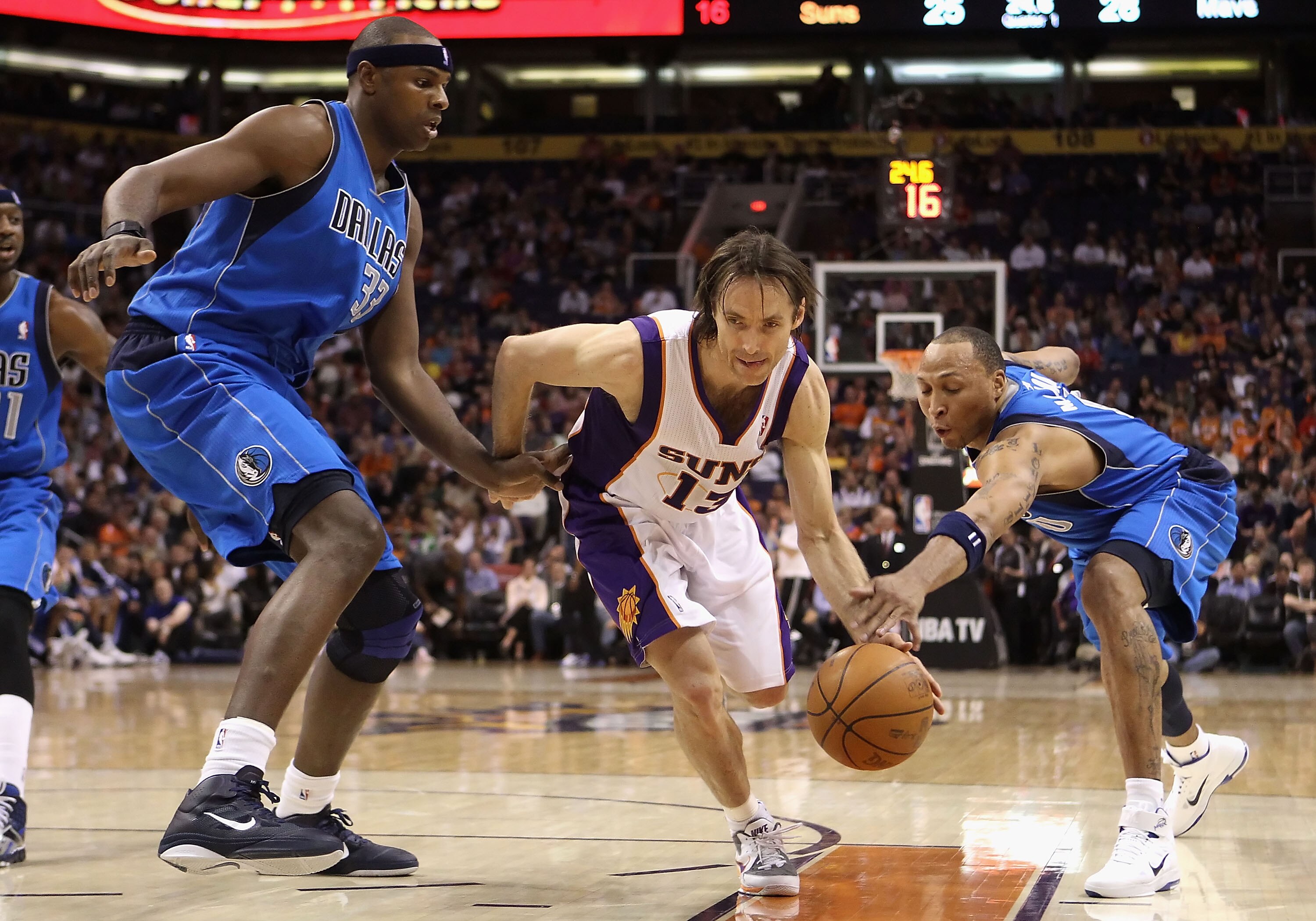 PHOENIX, AZ - FEBRUARY 17:  Steve Nash #13 of the Phoenix Suns drives the ball between Brendan Haywood #33 and Shawn Marion #0 of the Dallas Mavericks during the NBA game at US Airways Center on February 17, 2011 in Phoenix, Arizona.  NOTE TO USER: User e