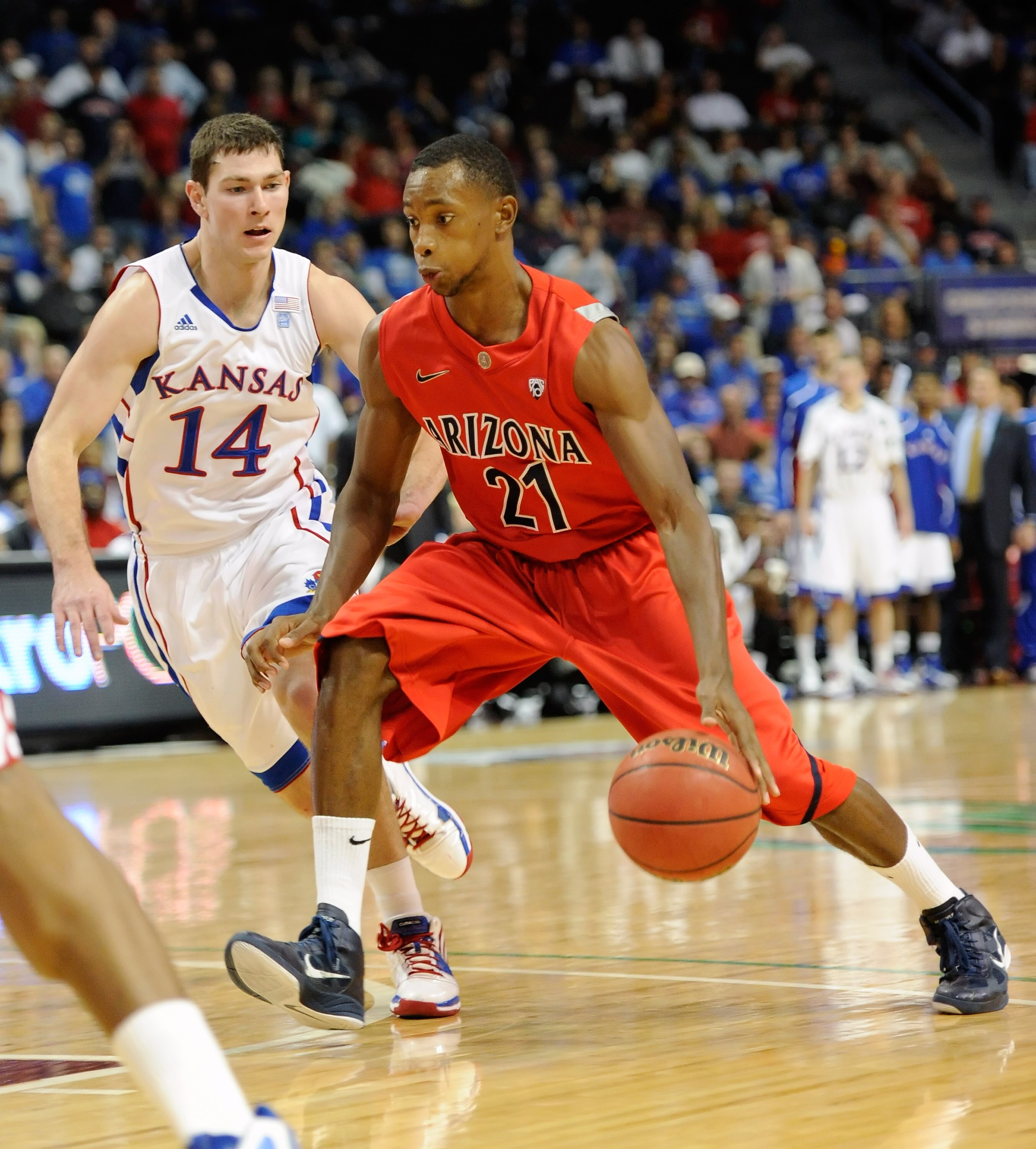LAS VEGAS - NOVEMBER 27:  Kyle Fogg #21 of the Arizona Wildcats drives against Tyrel Reed #14 of the Kansas Jayhawks during the championship game of the Las Vegas Invitational at The Orleans Arena November 27, 2010 in Las Vegas, Nevada. Kansas won 87-79.