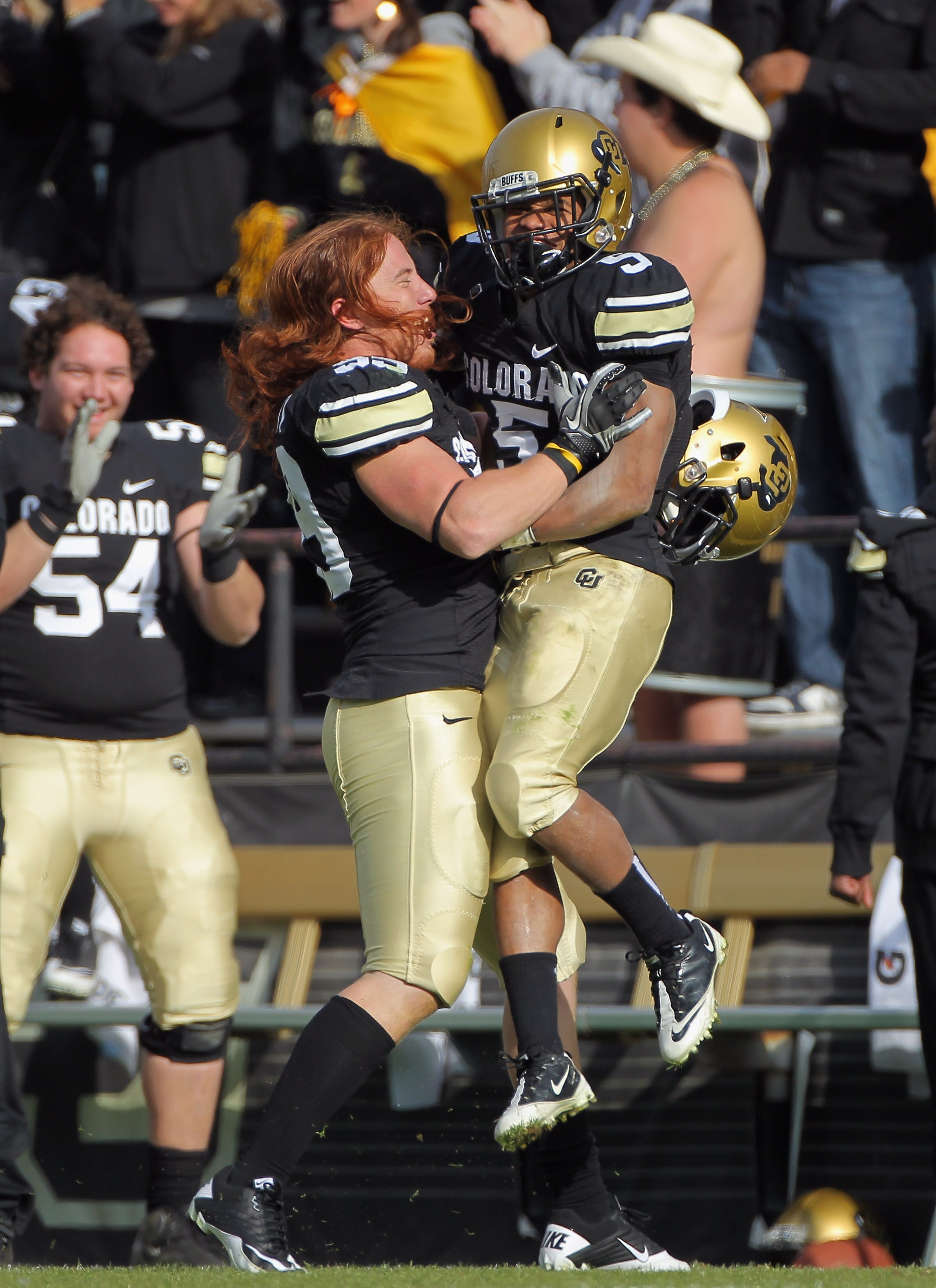 BOULDER, CO - NOVEMBER 20:  Running back Rodney Stewart #5 of the Colorado Buffaloes jumps into the arms of teammate BJ Beatty #59 as he celebrates after throwing an option pass 23 yards to Toney Clemons for a touchdown against the Kansas State Wildcats a