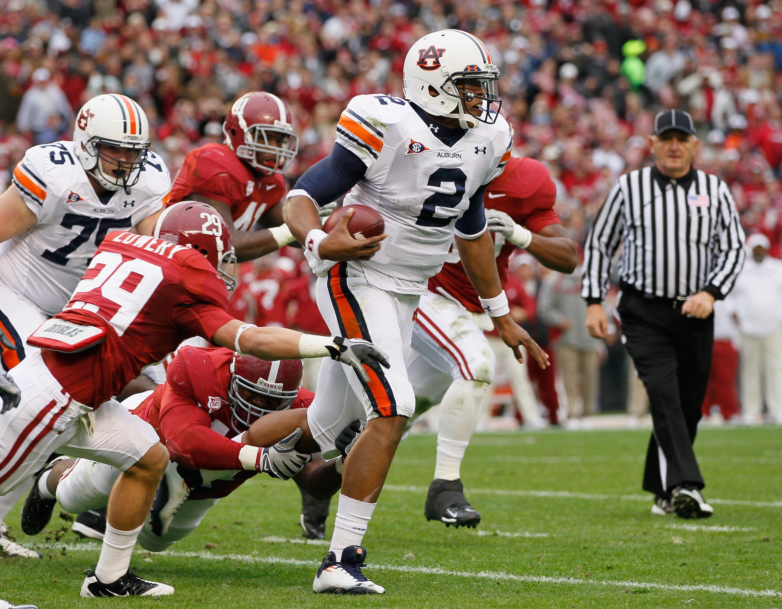 TUSCALOOSA, AL - NOVEMBER 26:  Quarterback Cam Newton #2 of the Auburn Tigers rushes upfield away from Will Lowery #29 and Marcell Dareus #57 of the Alabama Crimson Tide at Bryant-Denny Stadium on November 26, 2010 in Tuscaloosa, Alabama.  (Photo by Kevin