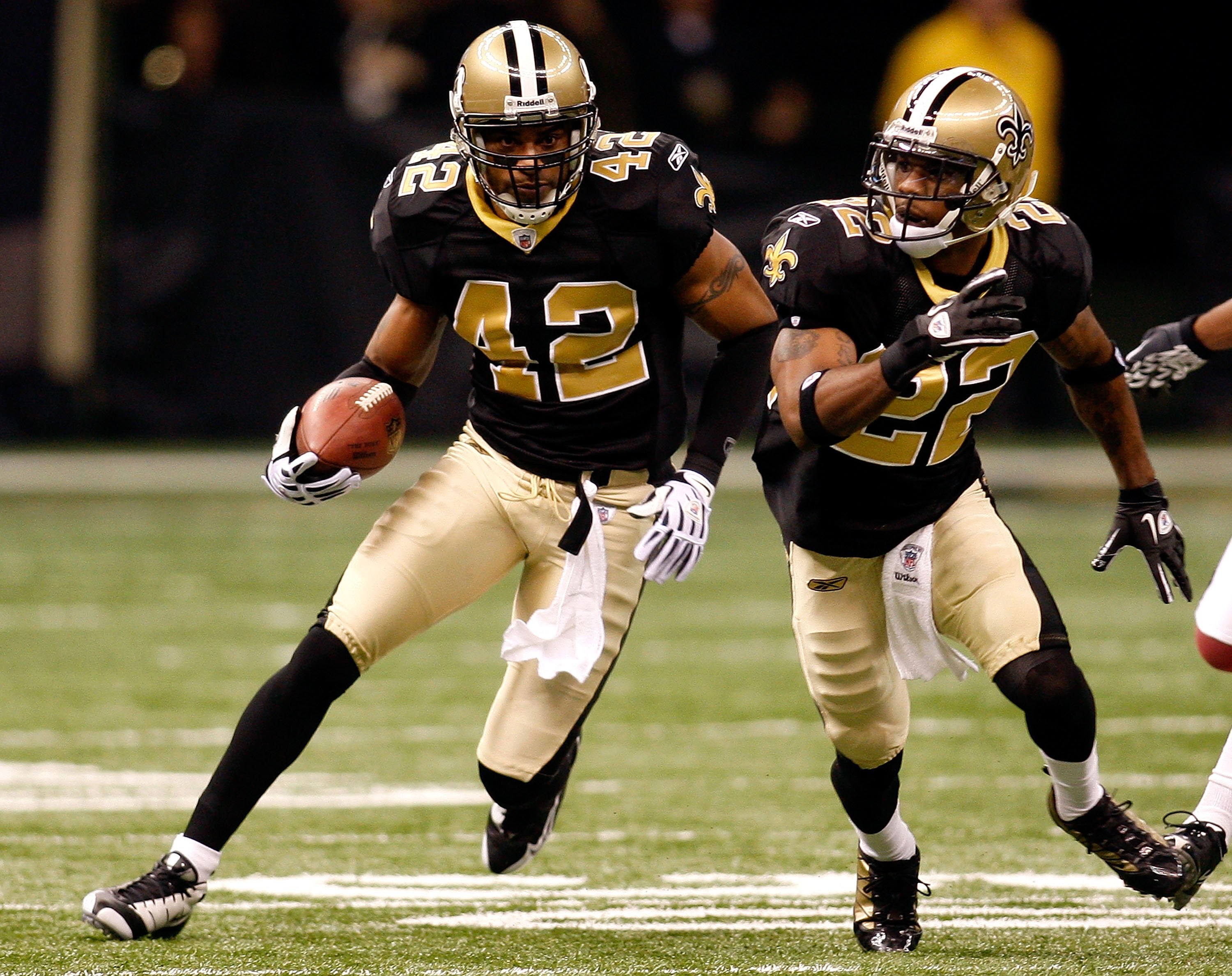 NEW ORLEANS - JANUARY 16:  Darren Sharper #42 of the New Orleans Saints returns a fumble recovery for positive yards as Tracy Porter #22 looks to block against the Arizona Cardinals during the NFC Divisional Playoff Game at Louisana Superdome on January 1