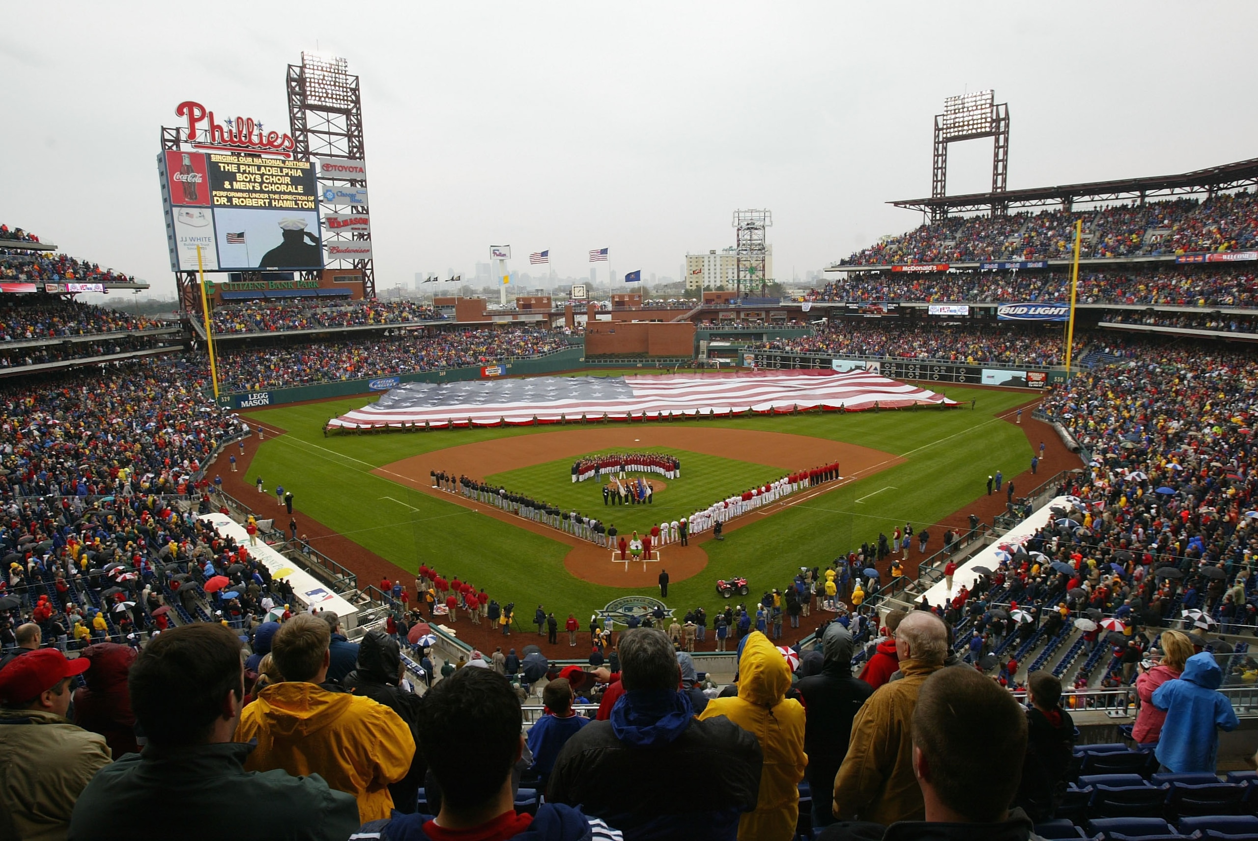 PHILADELPHIA - APRIL 12:  Military personel adorn the outfield with an American flag as the Philadelphia city skyline provides a back drop during opening ceremonies as the Philadelphia Phillies host the Cincinnati Reds during MLB action at the inaugural g