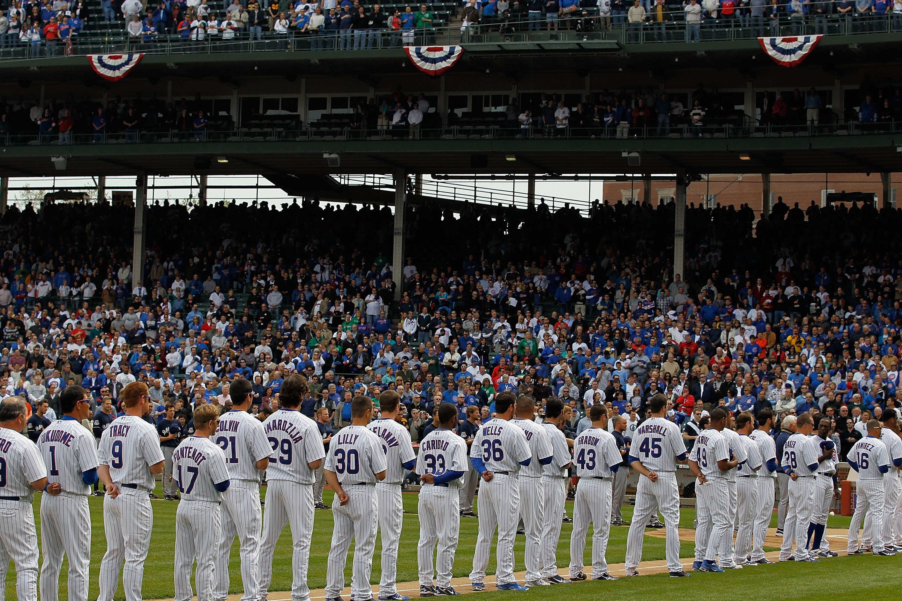 CHICAGO - APRIL 12: Members of the Chicago Cubs and the Milwaukee Brewers stand for the National Anthem on Opening Day at Wrigley Field on April 12, 2010 in Chicago, Illinois. (Photo by Jonathan Daniel/Getty Images)