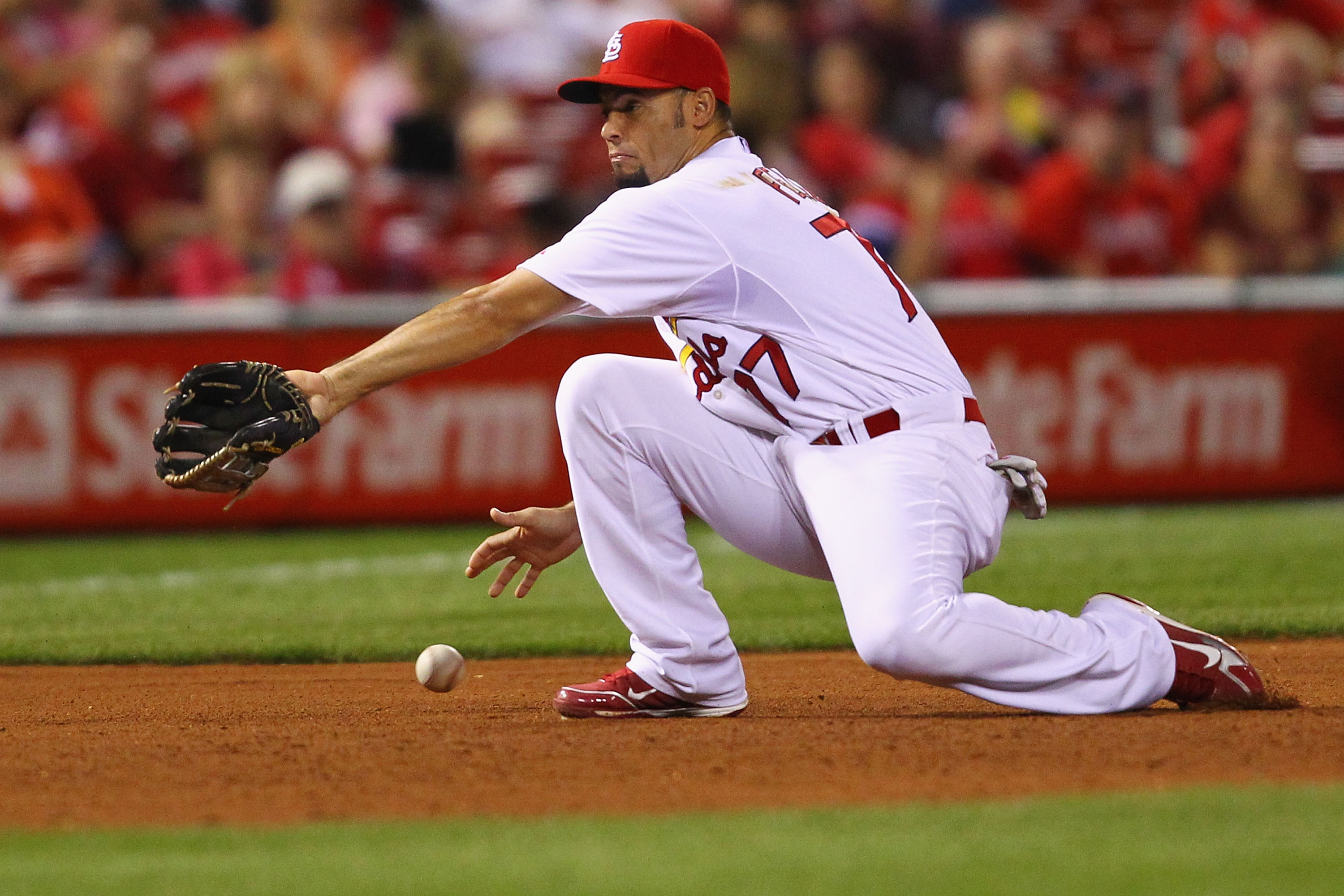 ST. LOUIS - SEPTEMBER 17: Pedro Feliz #77 of the St. Louis Cardinals misplays a ground ball against the San Diego Padres at Busch Stadium on September 17, 2010 in St. Louis, Missouri.  The Cardinals beat the Padres 14-4.  (Photo by Dilip Vishwanat/Getty I