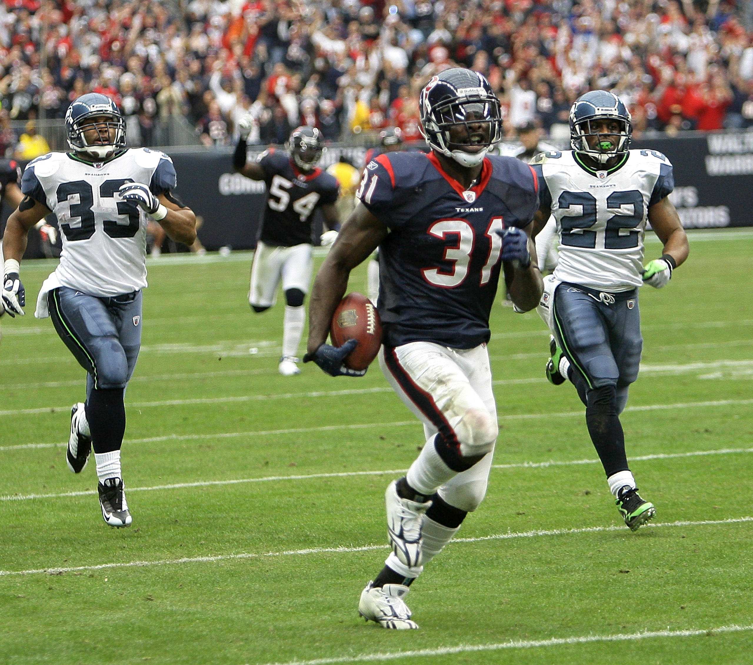 HOUSTON - DECEMBER 13:  Strong safety Bernard Pollard #31 of the Houston Texans runs back an inteception for 70 yards for a touchdown in the fourth quarter as Justin Griffith #33 and Julius Jones #22 of the Seattle Seahawks can't make the tackle at Relian