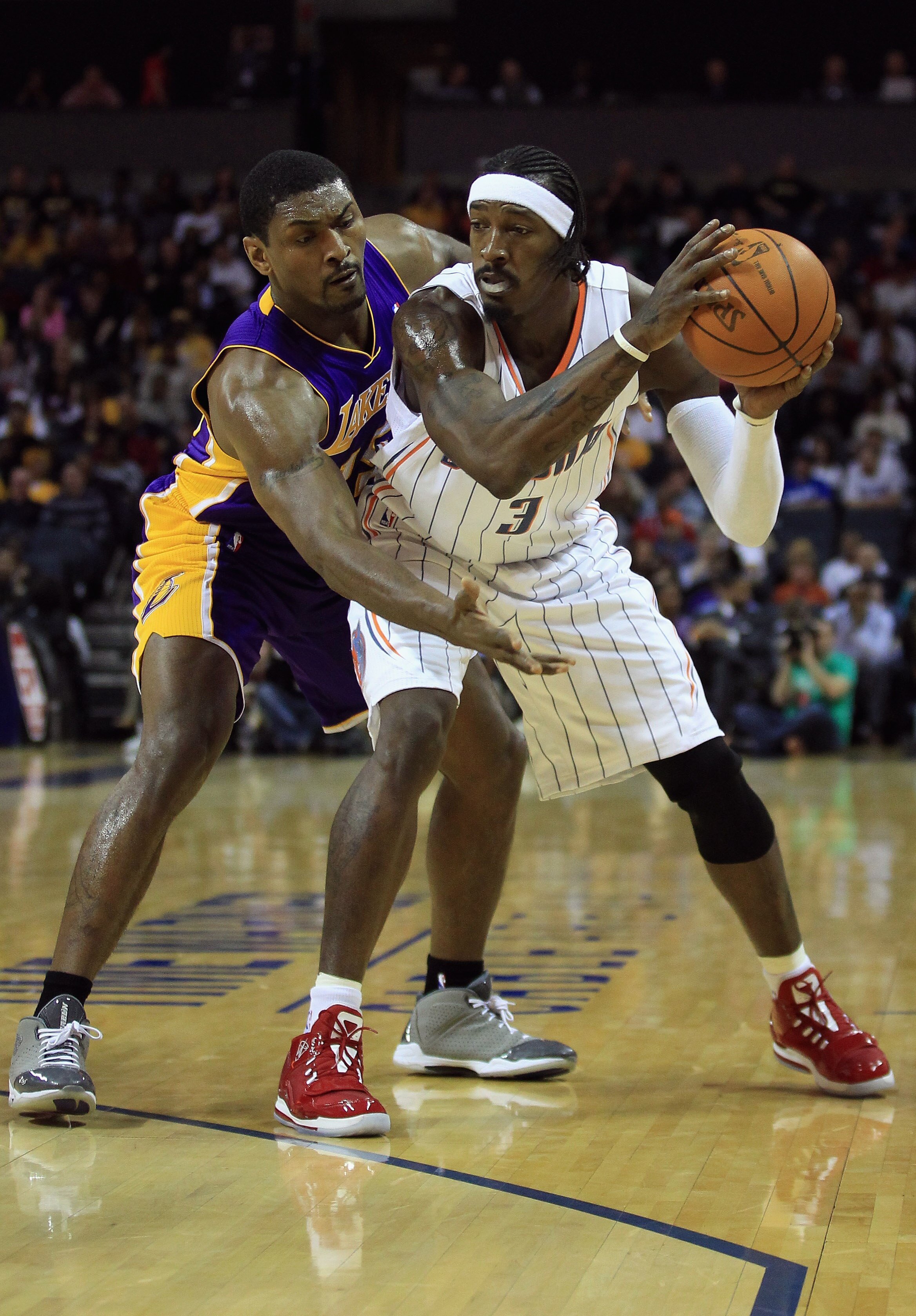CHARLOTTE, NC - FEBRUARY 14:  Ron Artest #15 of the Los Angeles Lakers reaches for the ball against Gerald Wallace #3 of the Charlotte Bobcats during their game at Time Warner Cable Arena on February 14, 2011 in Charlotte, North Carolina. NOTE TO USER: Us