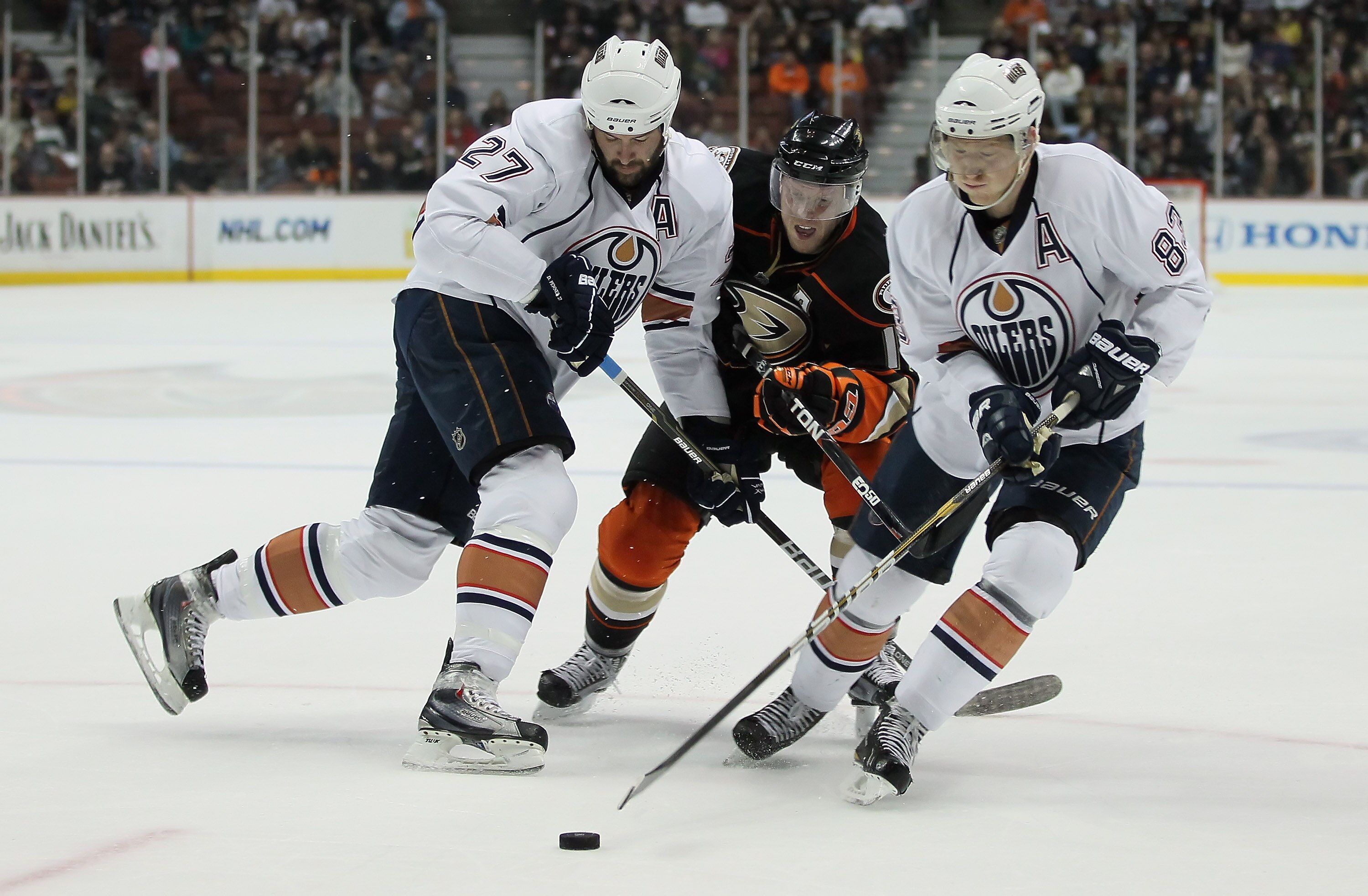 ANAHEIM, CA - JANUARY 16:  (L-R) Dustin Penner #27 of the Edmonton Oilers defends against Saku Koivu #11 of the Anaheim Ducks as Ales Hemsky #83 of the Oilers controls the puck in the first period at the Honda Center on January 16, 2011 in Anaheim, Califo