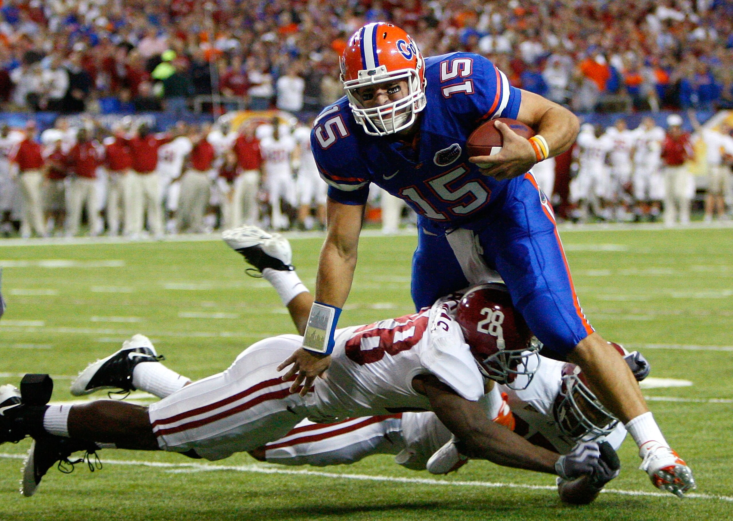 ATLANTA - DECEMBER 06:  Javier Arenas #28 and Justin Woodall #27 of the Alabama Crimson Tide tackle quarterback Tim Tebow #15 of the Florida Gators during the SEC Championship on December 6, 2008 at the Georgia Dome in Atlanta, Georgia.  (Photo by Kevin C