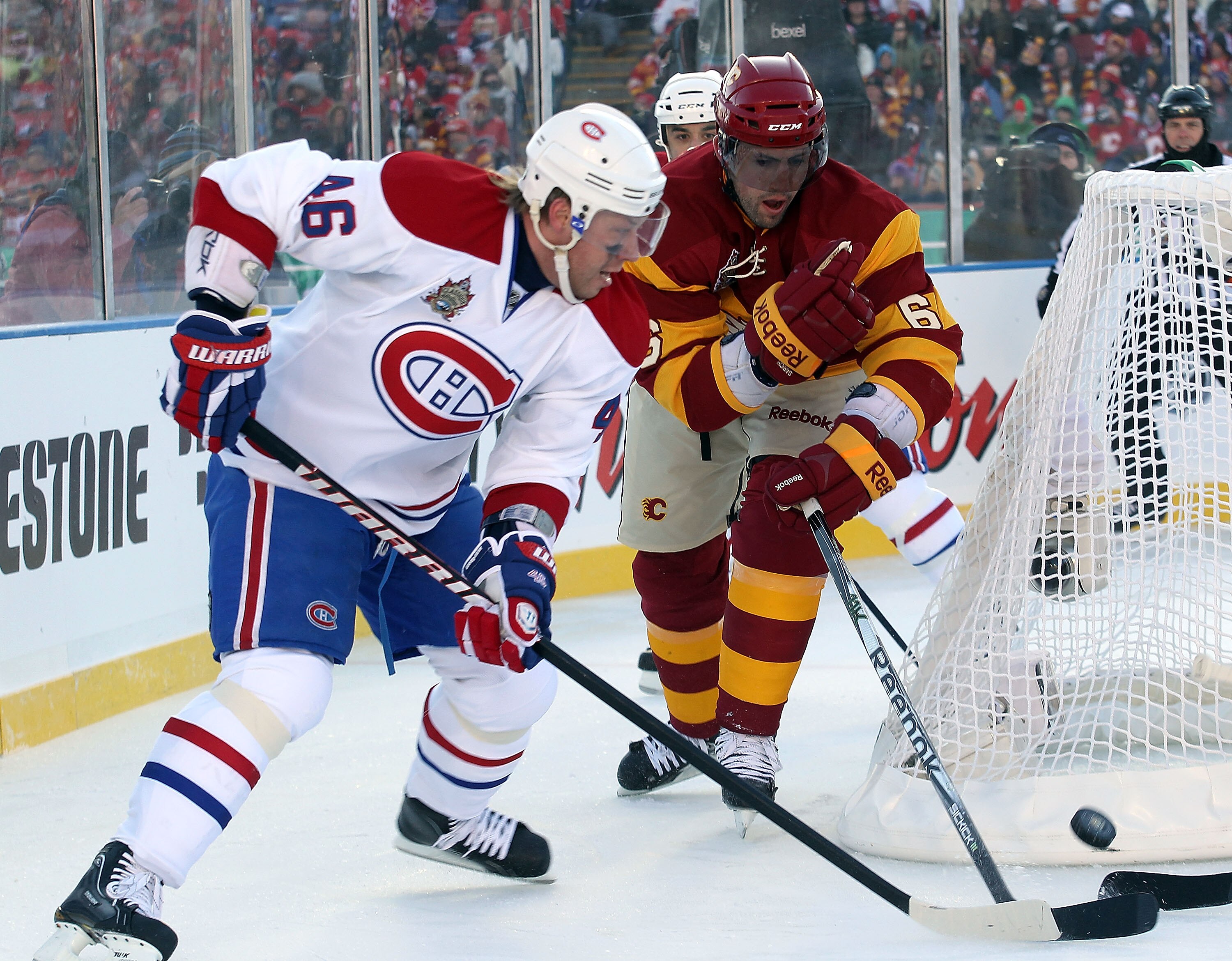 CALGARY, AB - FEBRUARY 20: Cory Sarich #6 of the Calgary Flames checks Andrei Kostitsyn #46 of the Montreal Canadiens during the 2011 NHL Heritage Classic Game at McMahon Stadium on February 20, 2011 in Calgary, Alberta, Canada.  (Photo by Andre Ringuette