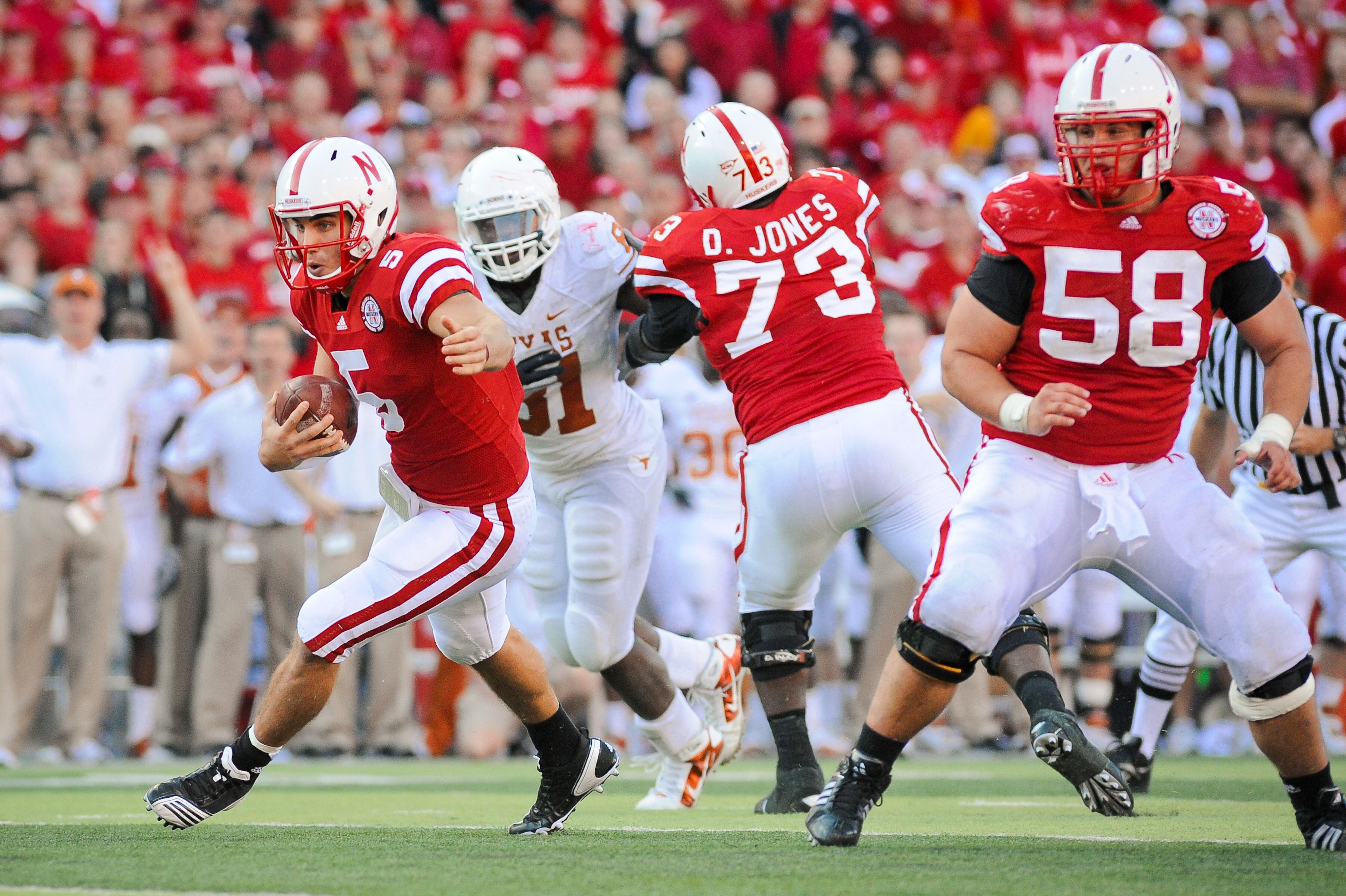 LINCOLN, NE - OCTOBER 16: Quarterback Zac Lee #5 of the Nebraska Cornhuskers runs through a hole created by offensive linesman Mike Caputo #58 and D.J. Jones #73 of the Nebraska Cornhuskers during their game at Memorial Stadium on October 16, 2010 in Linc