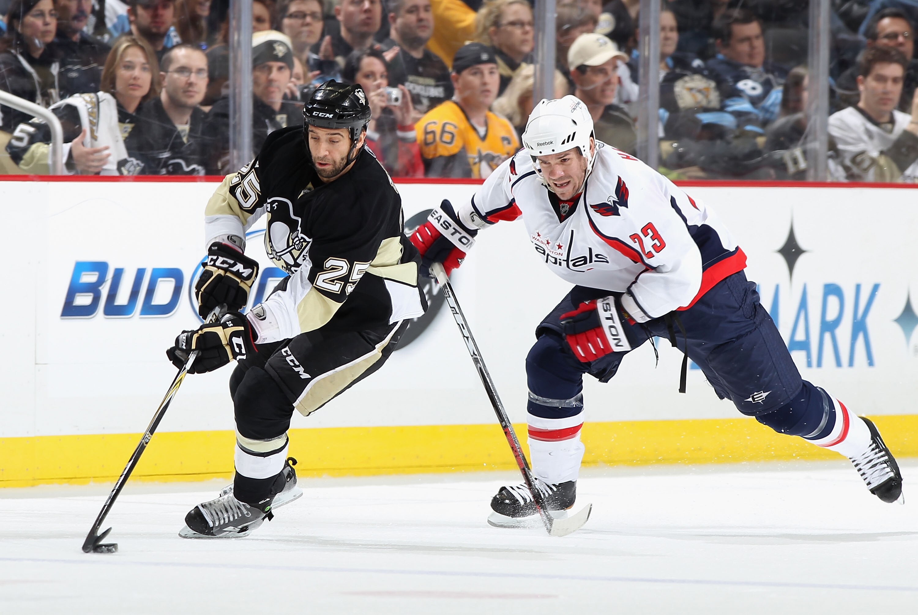 PITTSBURGH, PA - FEBRUARY 21:  Maxime Talbot #25 of the Pittsburgh Penguins skates with the puck past Scott Hannan #23 of the Washington Capitals during the NHL game at Consol Energy Center on February 21, 2011 in Pittsburgh, Pennsylvania. The Capitals de